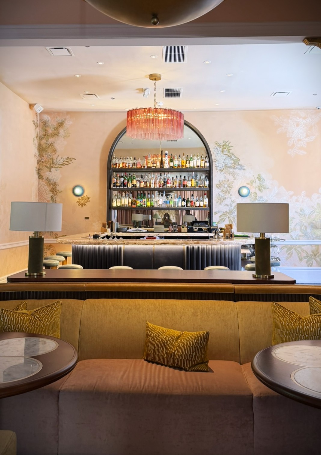 Modern hotel bar interior with grand piano, neon 'bar by fleeting' sign, and illuminated bottle display