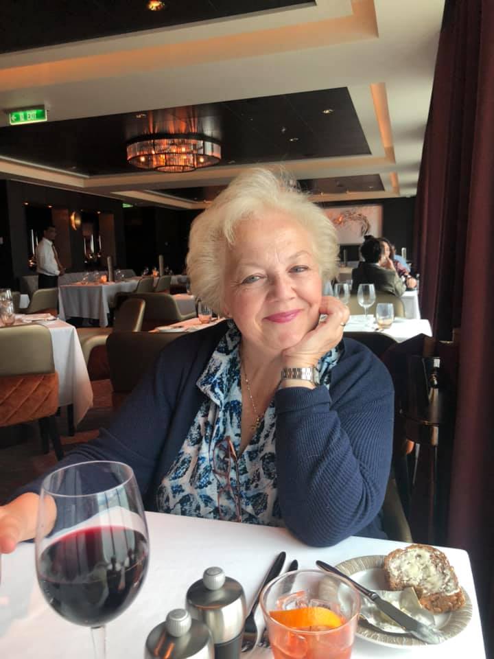 Patti Carter dining indoors at an elegant restaurant table with wine and appetizers