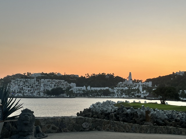 Waterfront view of white colonial buildings reflected in still water at dusk in Manzanillo