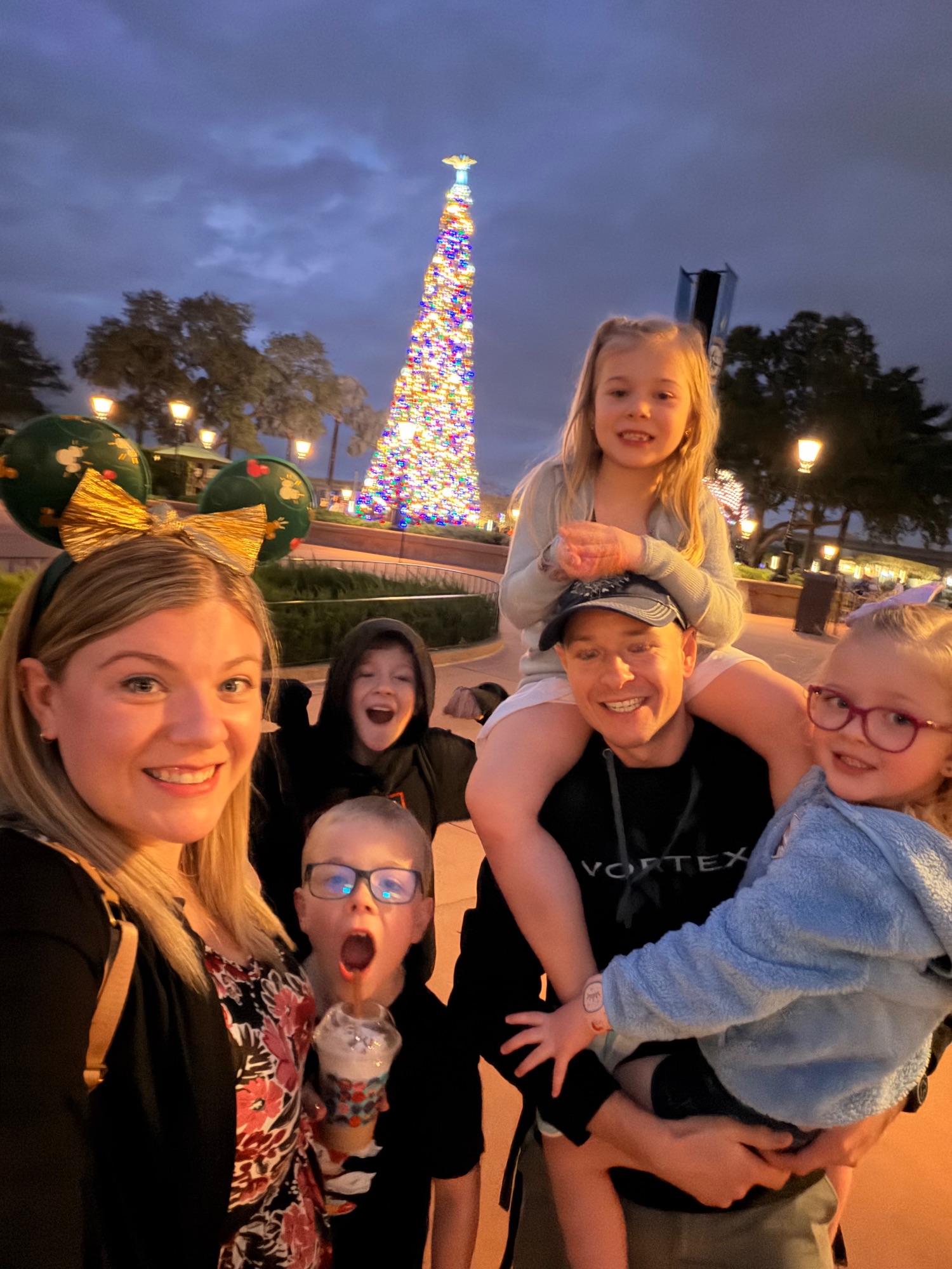 Family of six standing in front of Cinderella Castle at Magic Kingdom with colorful balloons