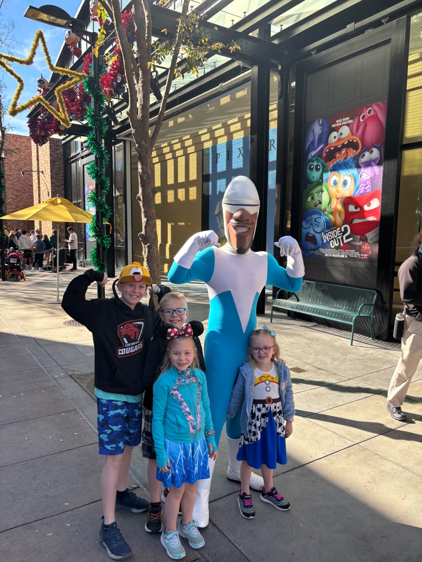 Family of seven standing in front of a large circus-themed entrance sign at a theme park
