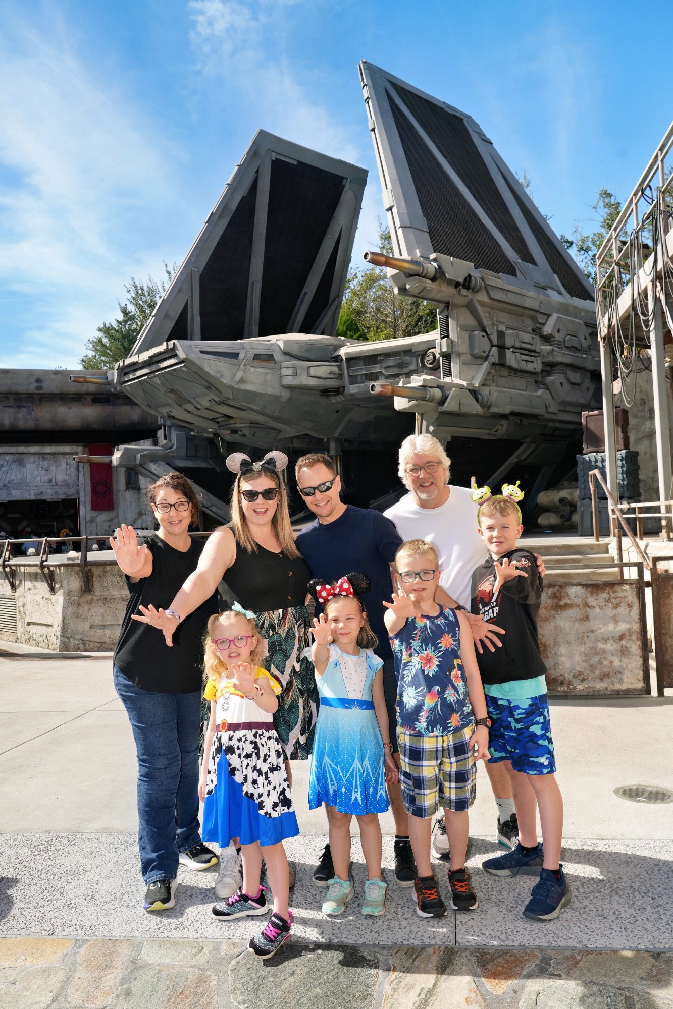 Family of six posing in front of a TIE fighter spacecraft replica at an indoor Star Wars-themed attraction