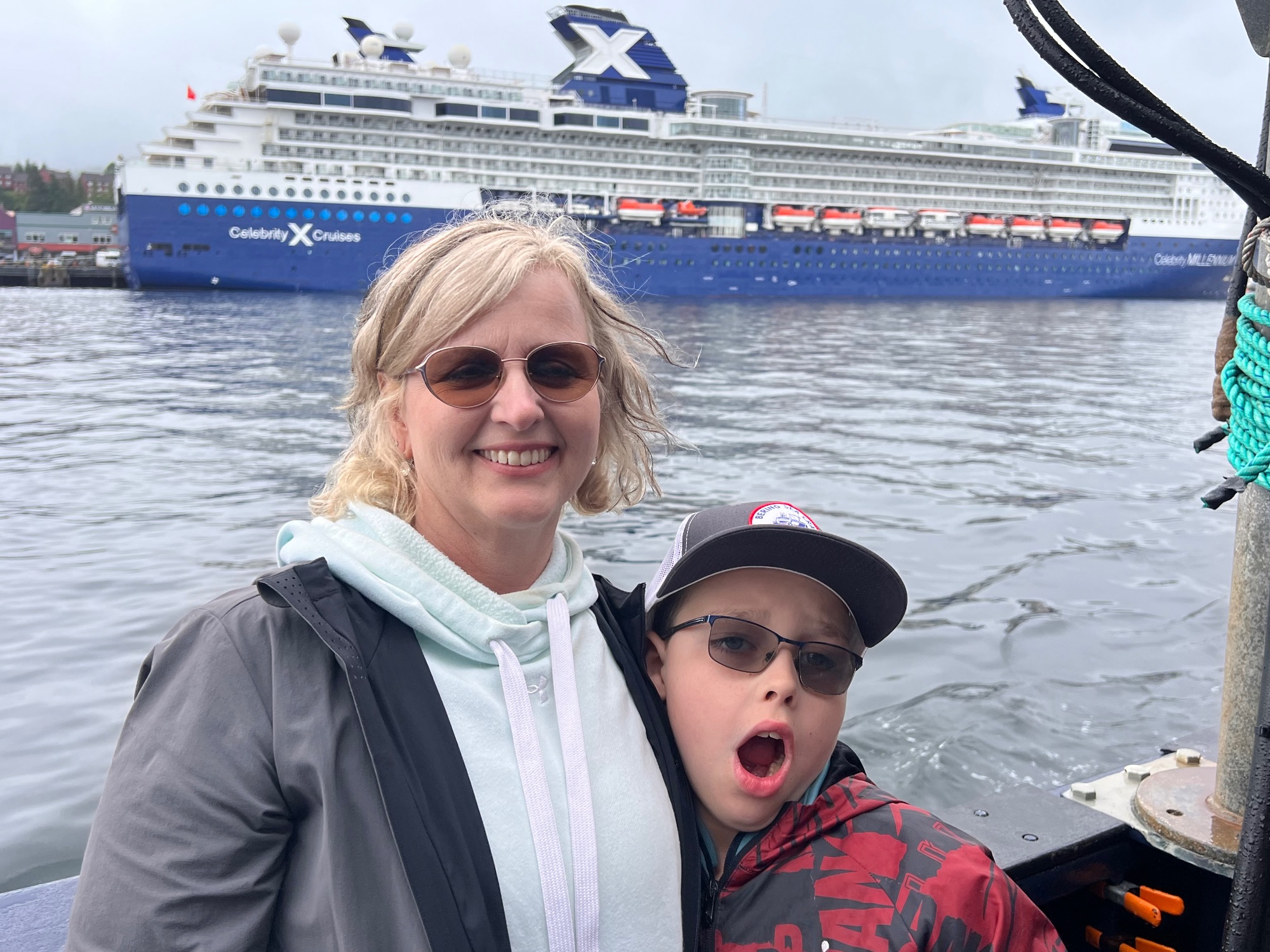 Woman and child on cruise ship deck with Celebrity Cruises ship visible in background