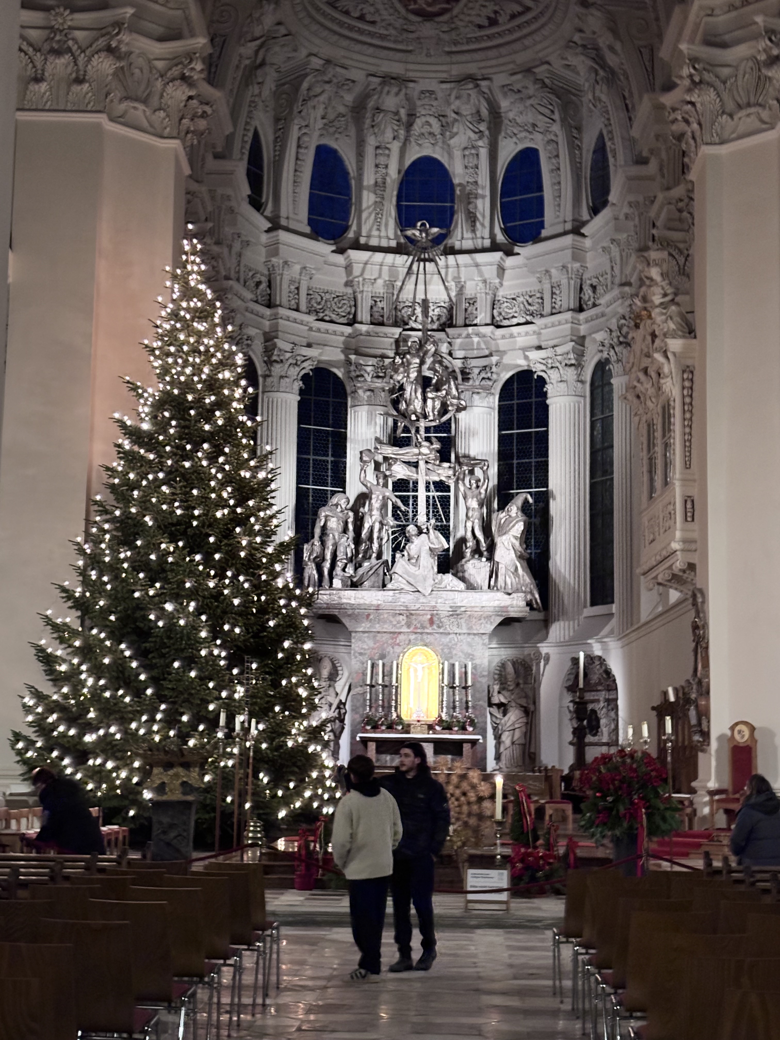 Ornate white cathedral interior with a decorated Christmas tree and blue windows