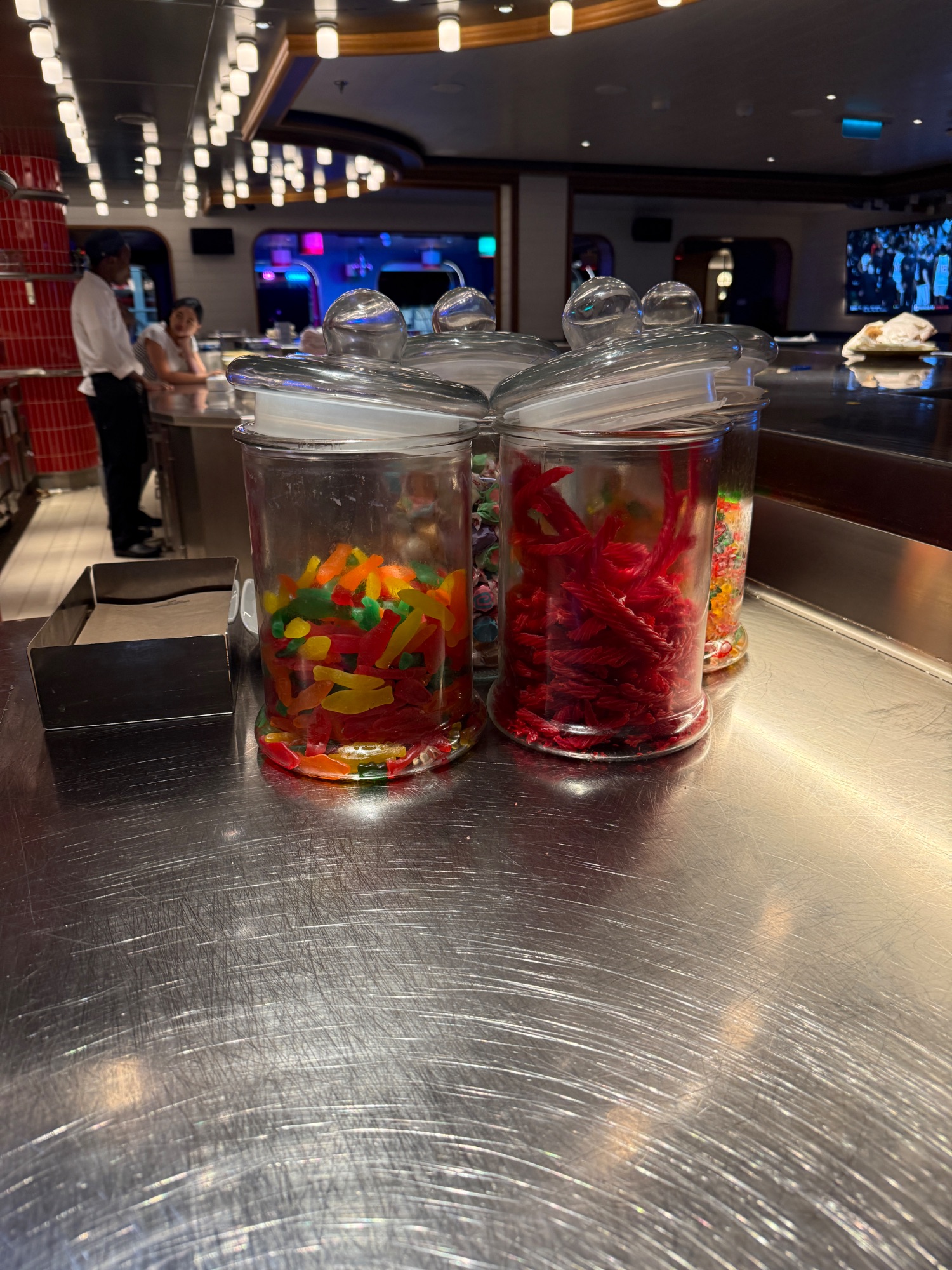 Colorful candy jars displayed on ship counter with gummy bears and sweets