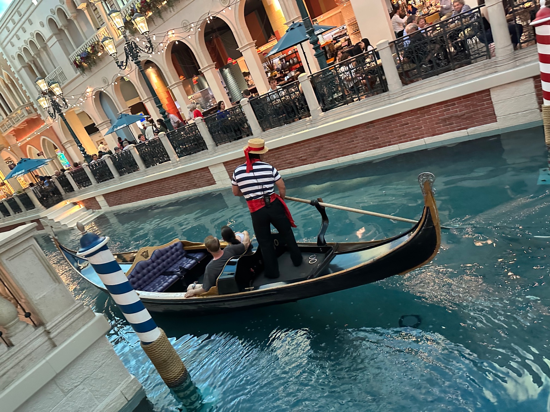Venetian Hotel's Grand Canal Shoppes with gondola and gondolier in striped shirt on indoor canal