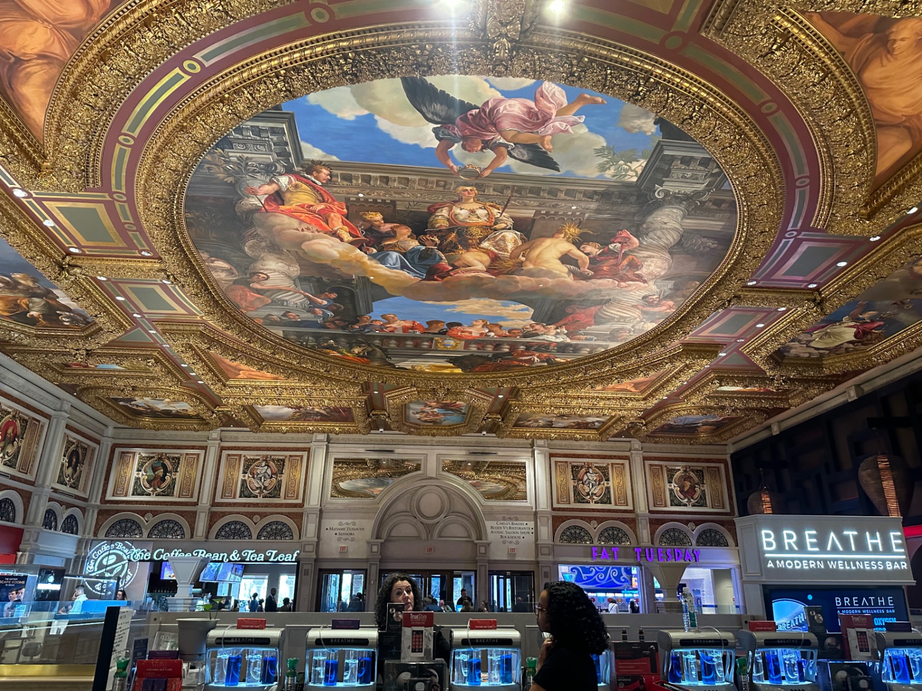 Grand ornate ceiling with gold leaf framing and classical religious artwork in historic casino theater