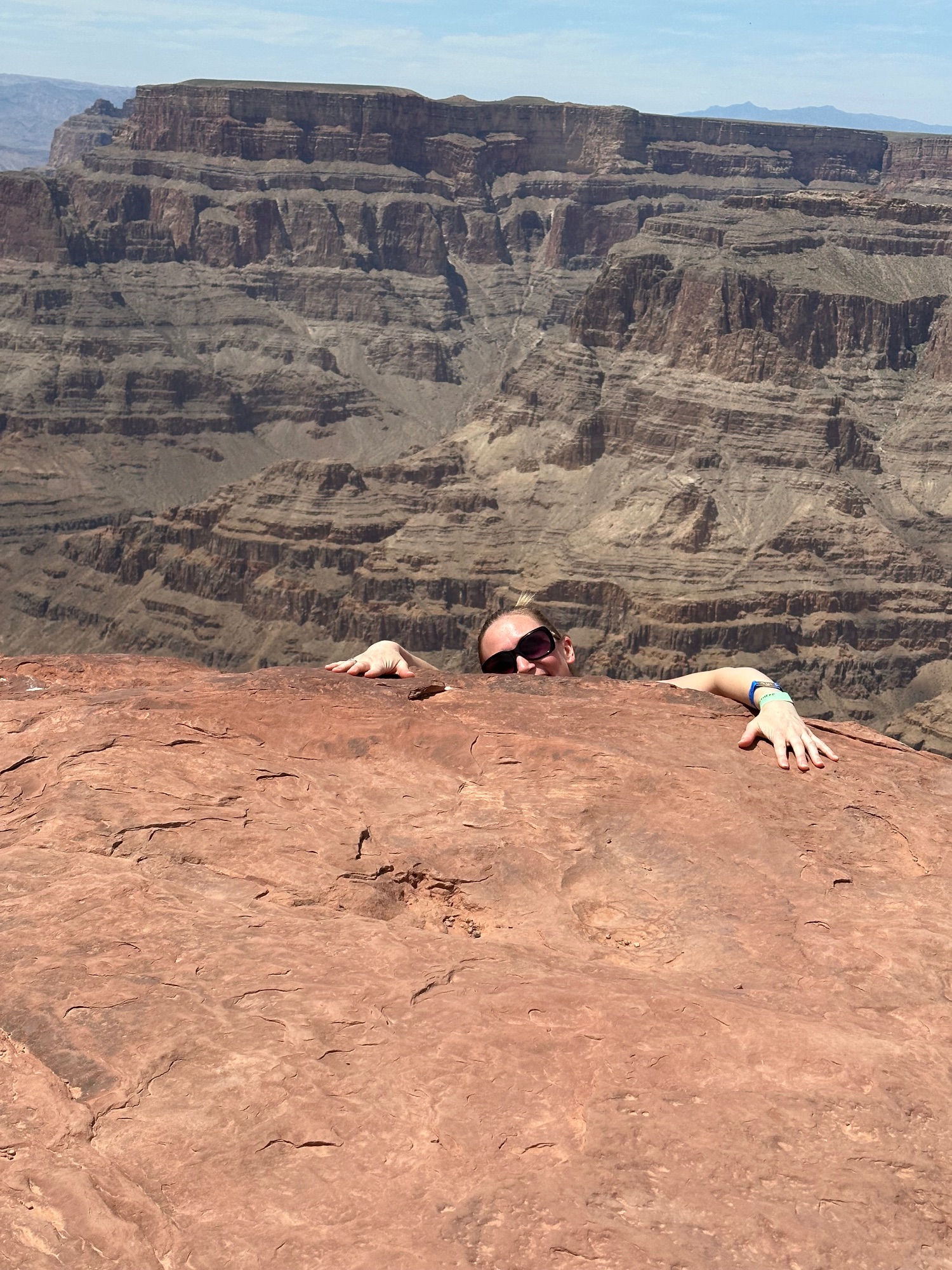 Grand Canyon overlook with red rock formations, layered canyon walls, and visitors on observation point