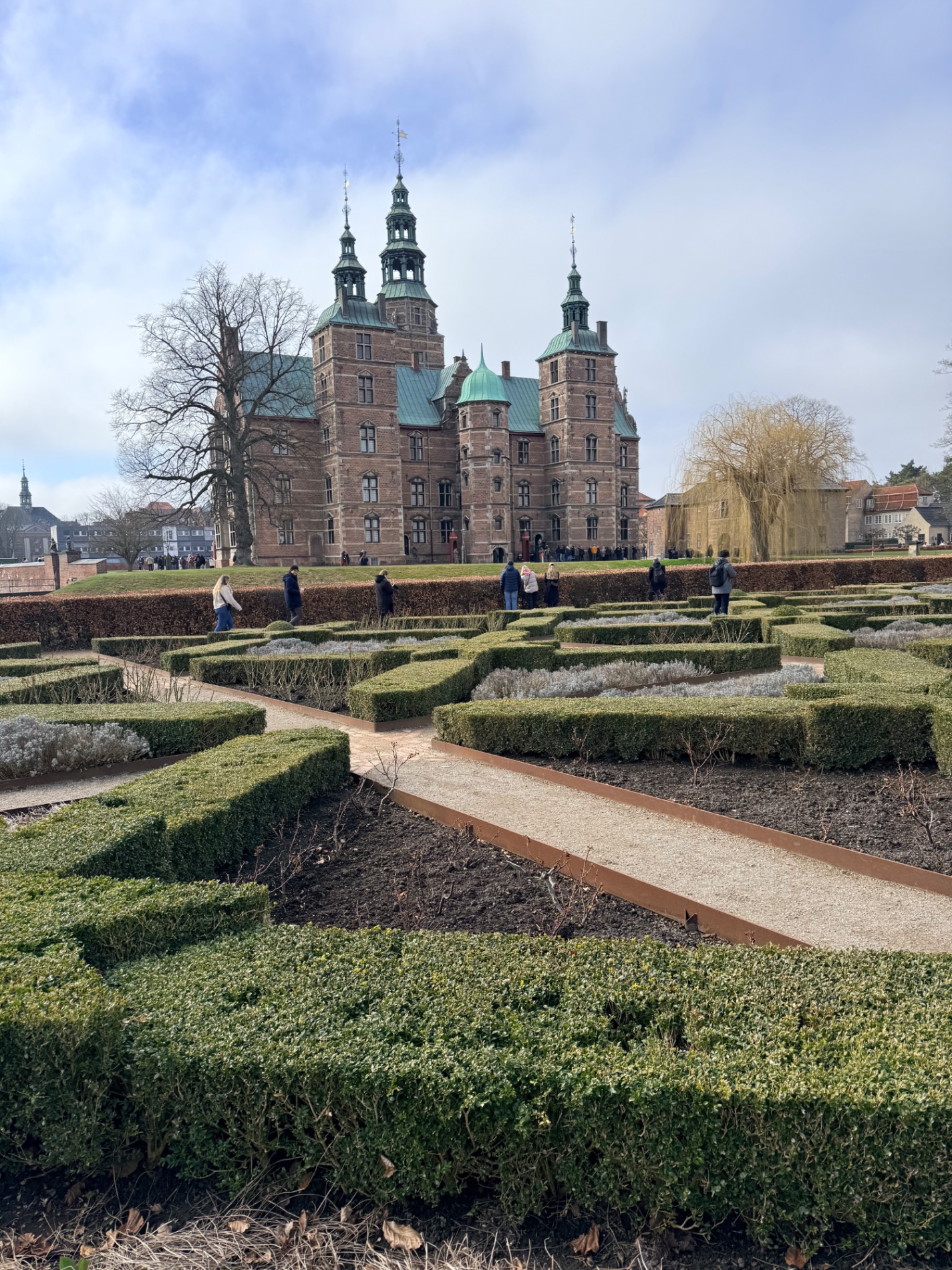 Rosenborg Castle with distinctive copper-green spires and red brick architecture surrounded by formal hedge gardens