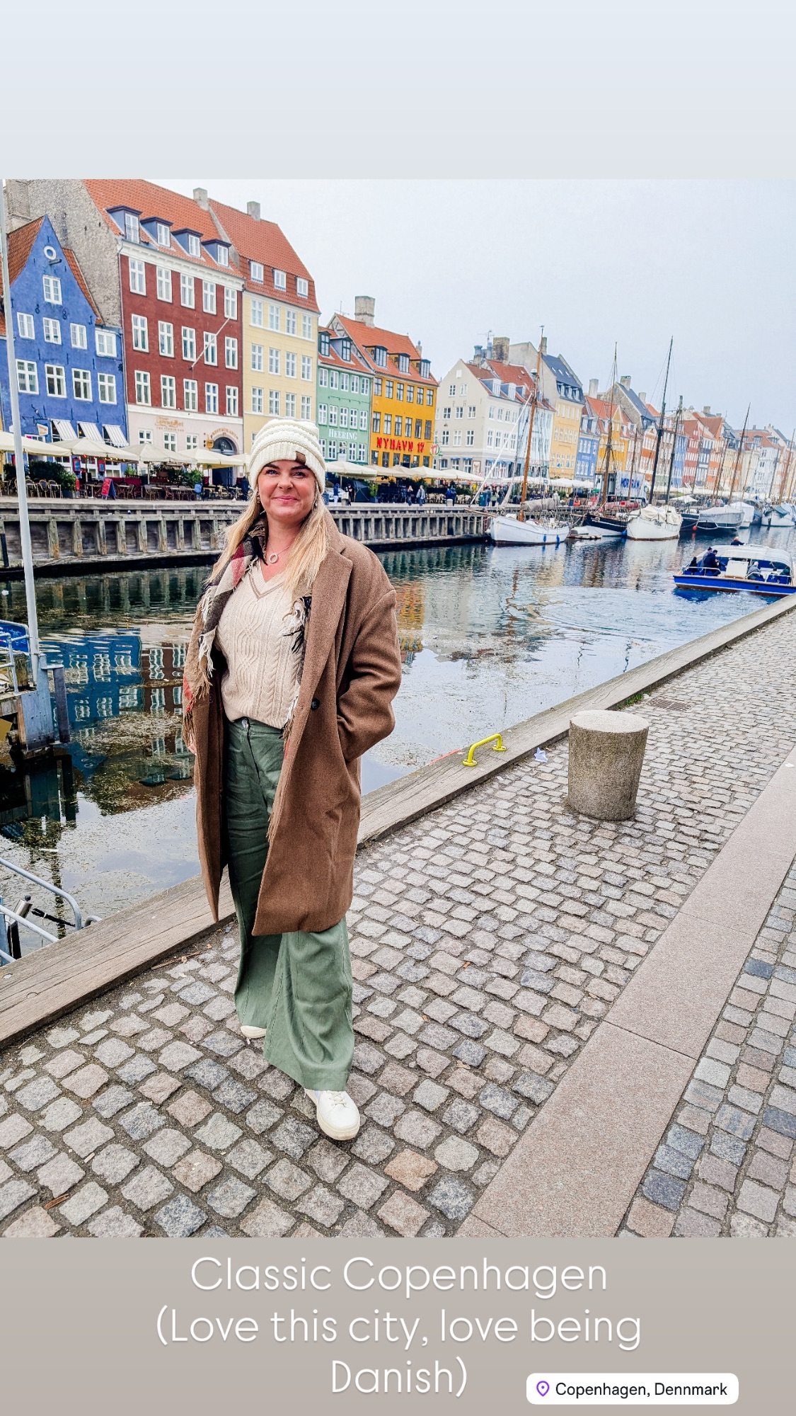 The Little Mermaid statue sitting on a rock overlooking calm gray water in Copenhagen harbor