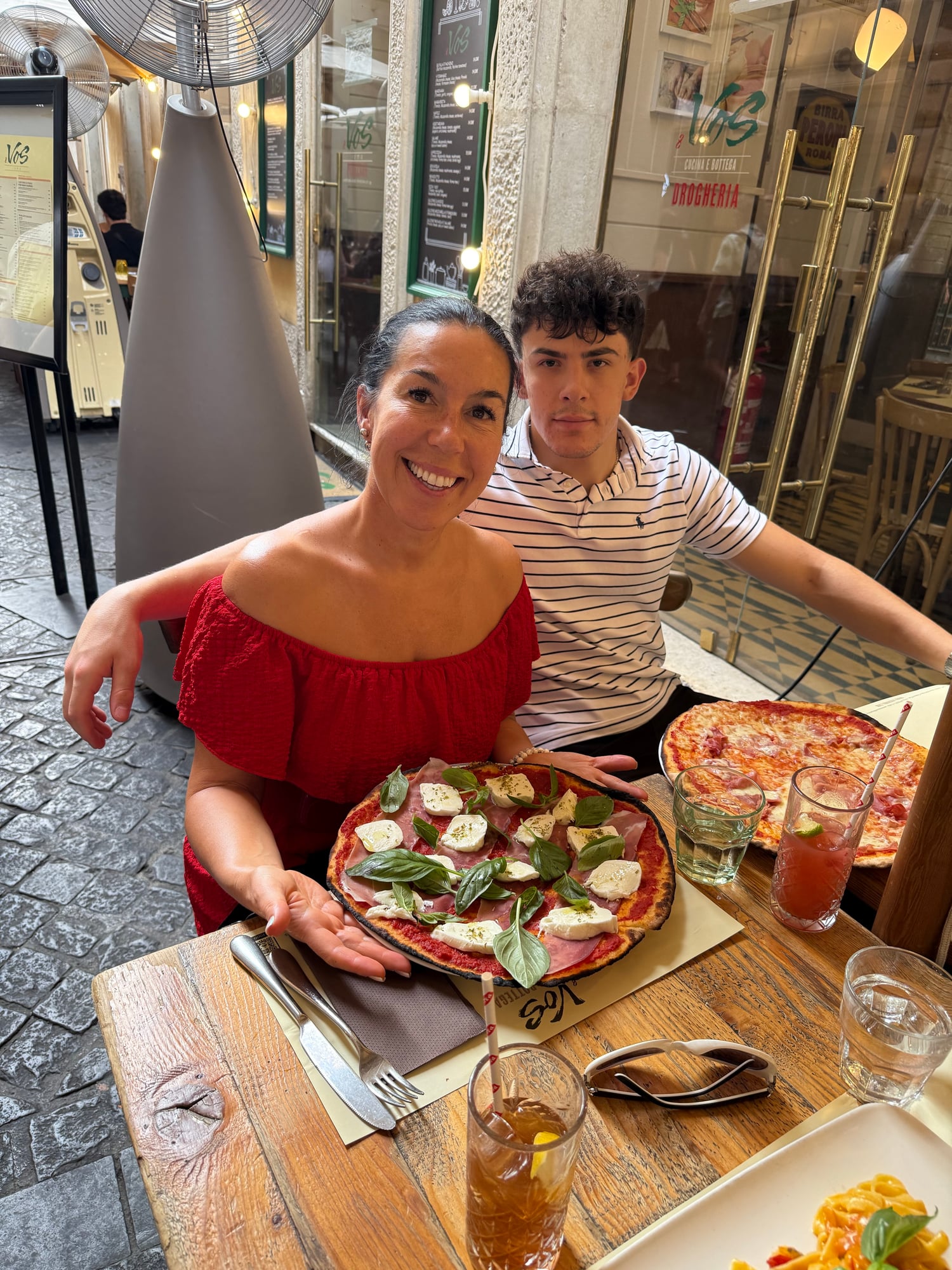 Katia and a young man enjoy Margherita pizza at an outdoor restaurant in Rome's historic center