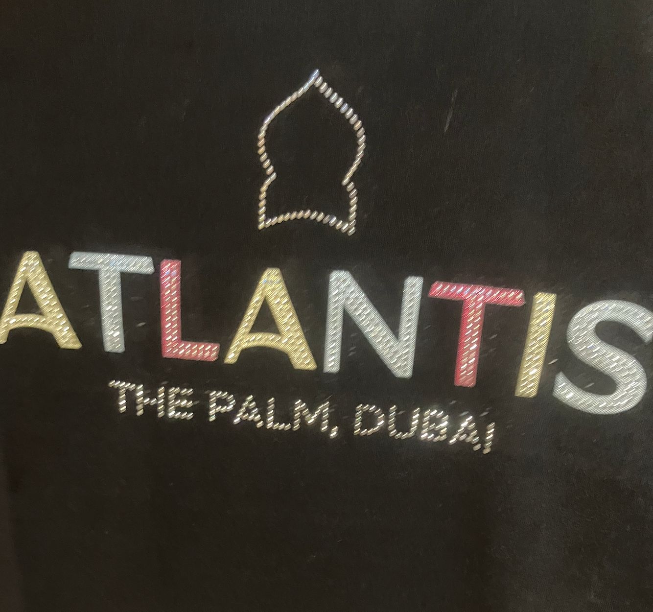 Woman posing at Dubai booth next to illuminated neon signage at a travel trade show