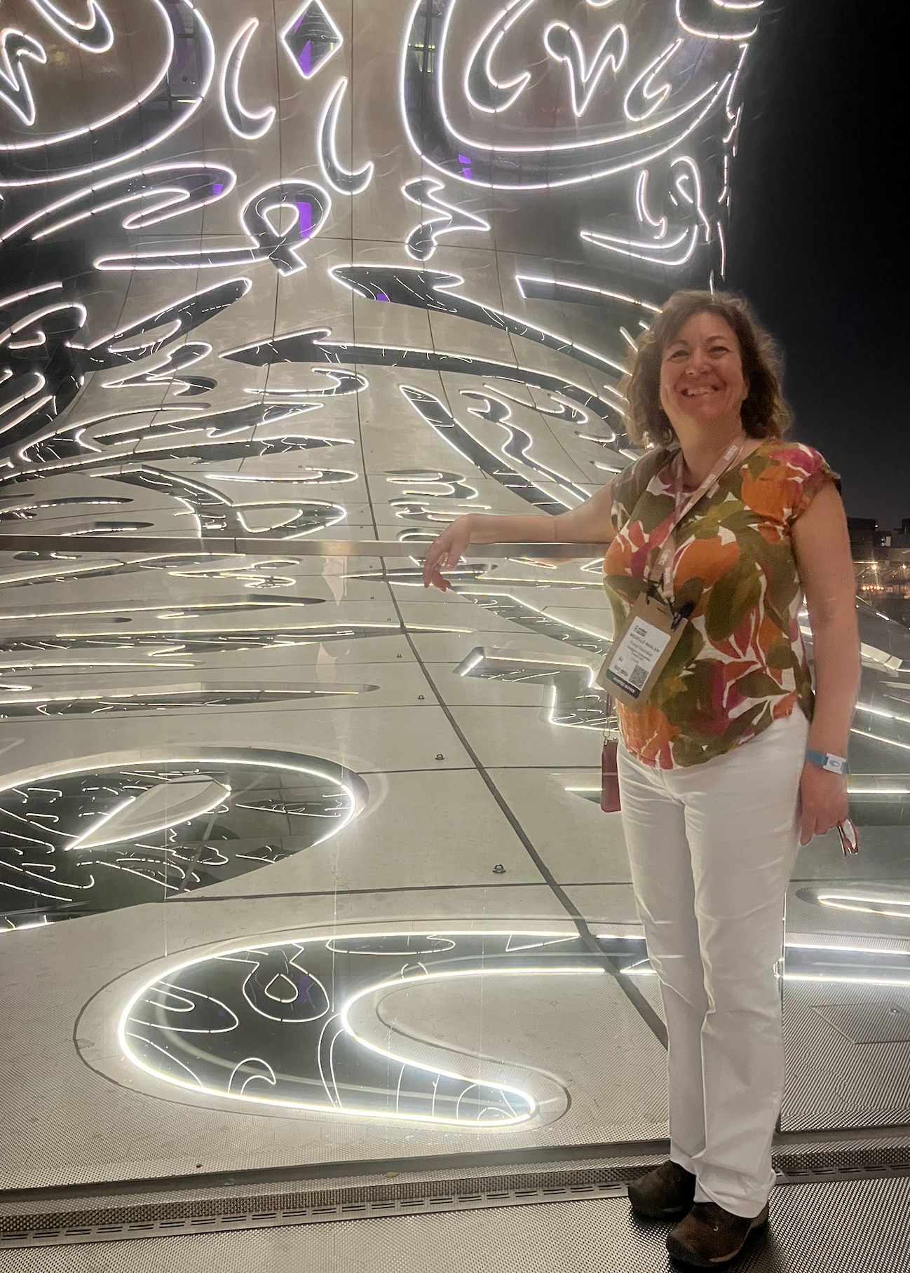 Illuminated waterfall feature in shopping mall with white aircraft silhouettes projected on dark textured wall