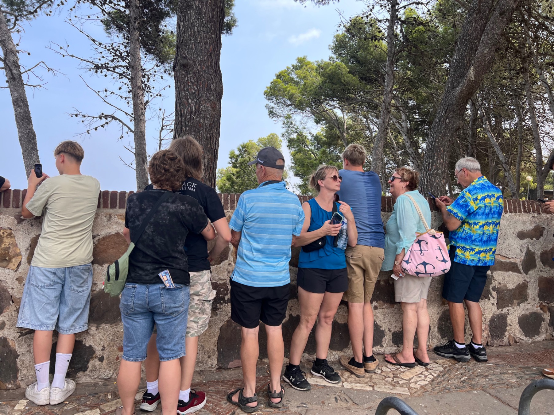 Group of tourists on an open-air bus tour through Barcelona streets with city buildings visible