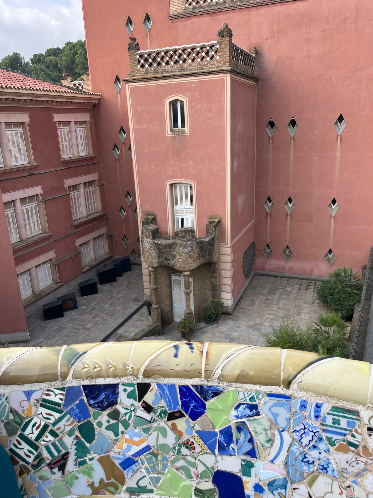 Colorful mosaic dragon sculpture at Park Güell with intricate blue, green, and white tile patterns