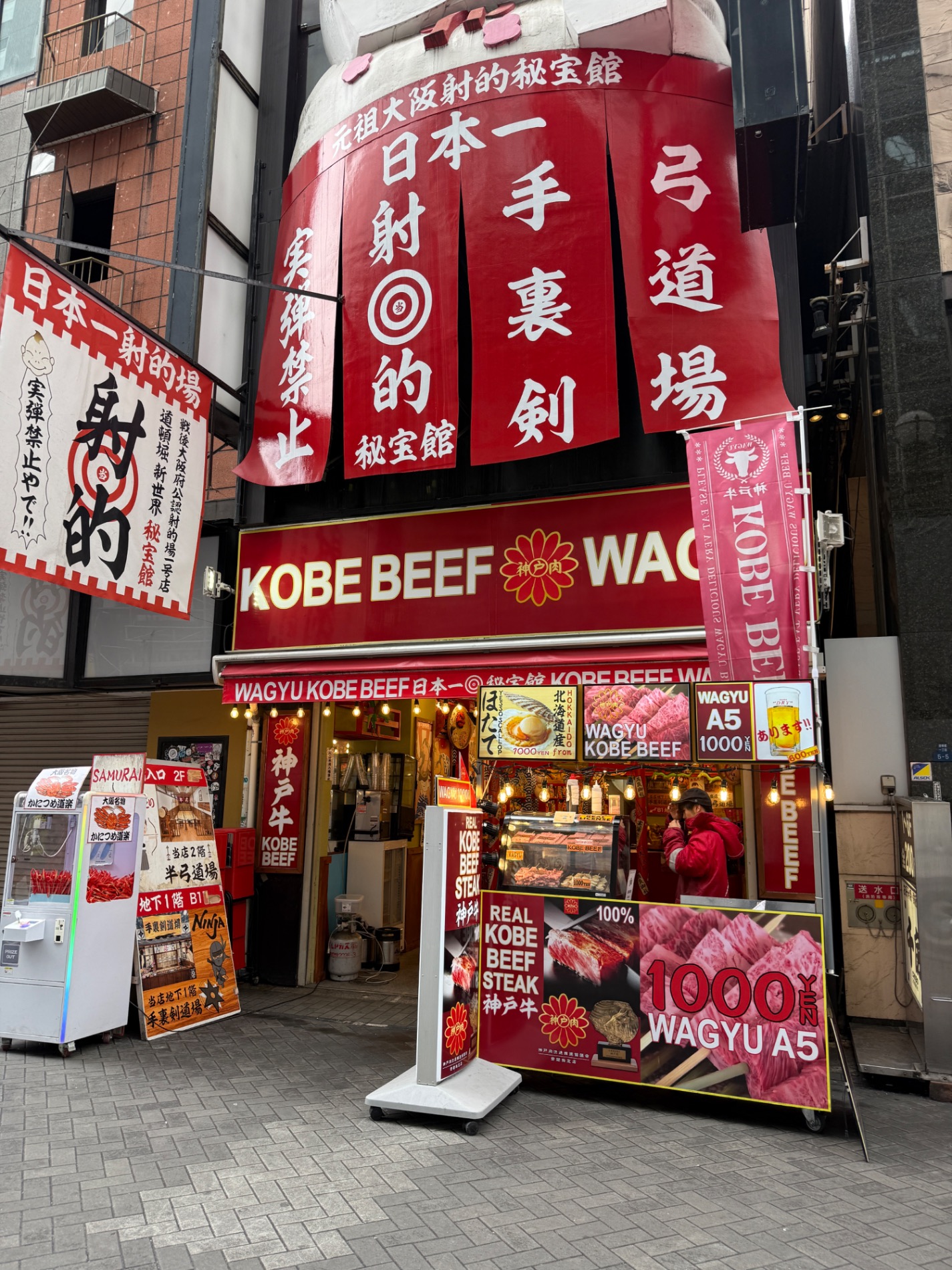 Storefront of Wagyu Kobe Beef restaurant with large red signage, Japanese characters, and promotional displays