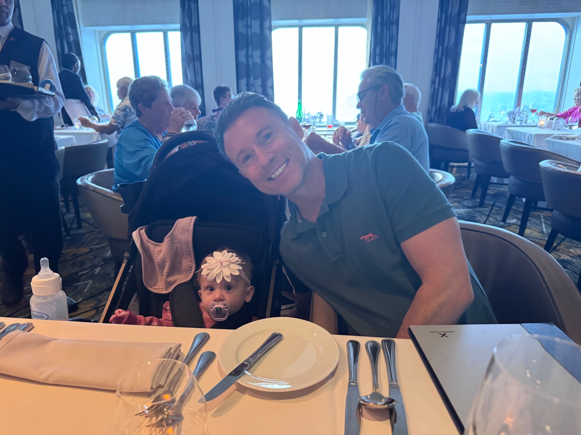 Baby in a black stroller on a cruise ship pool deck with ocean view