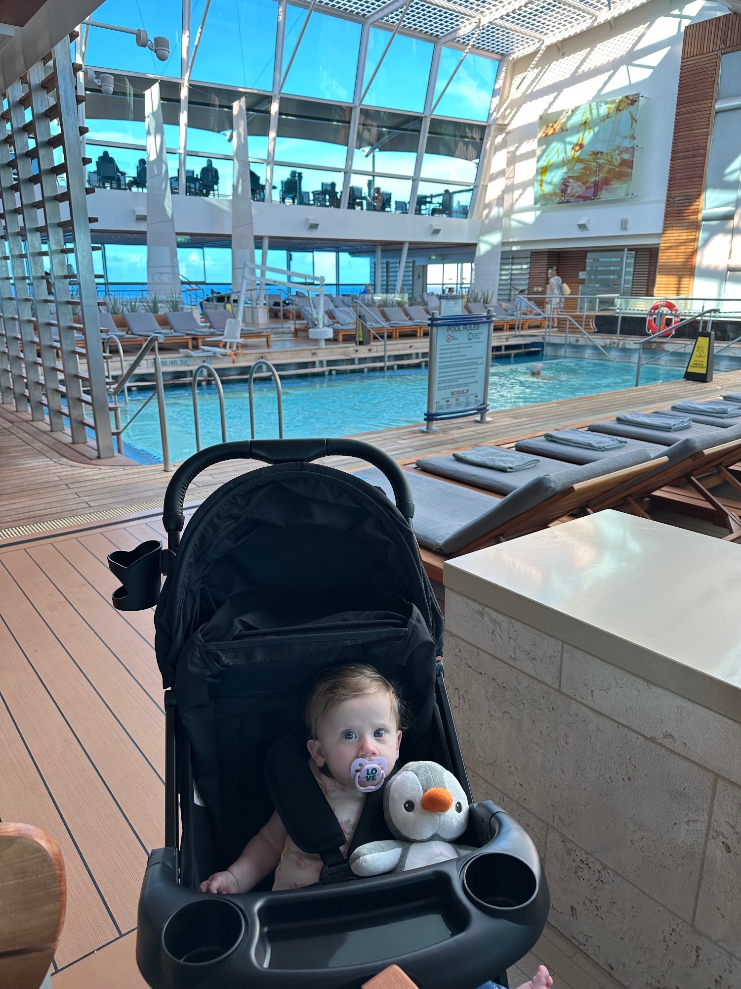 Man in casual wear holding a baby in a modern cruise ship dining room