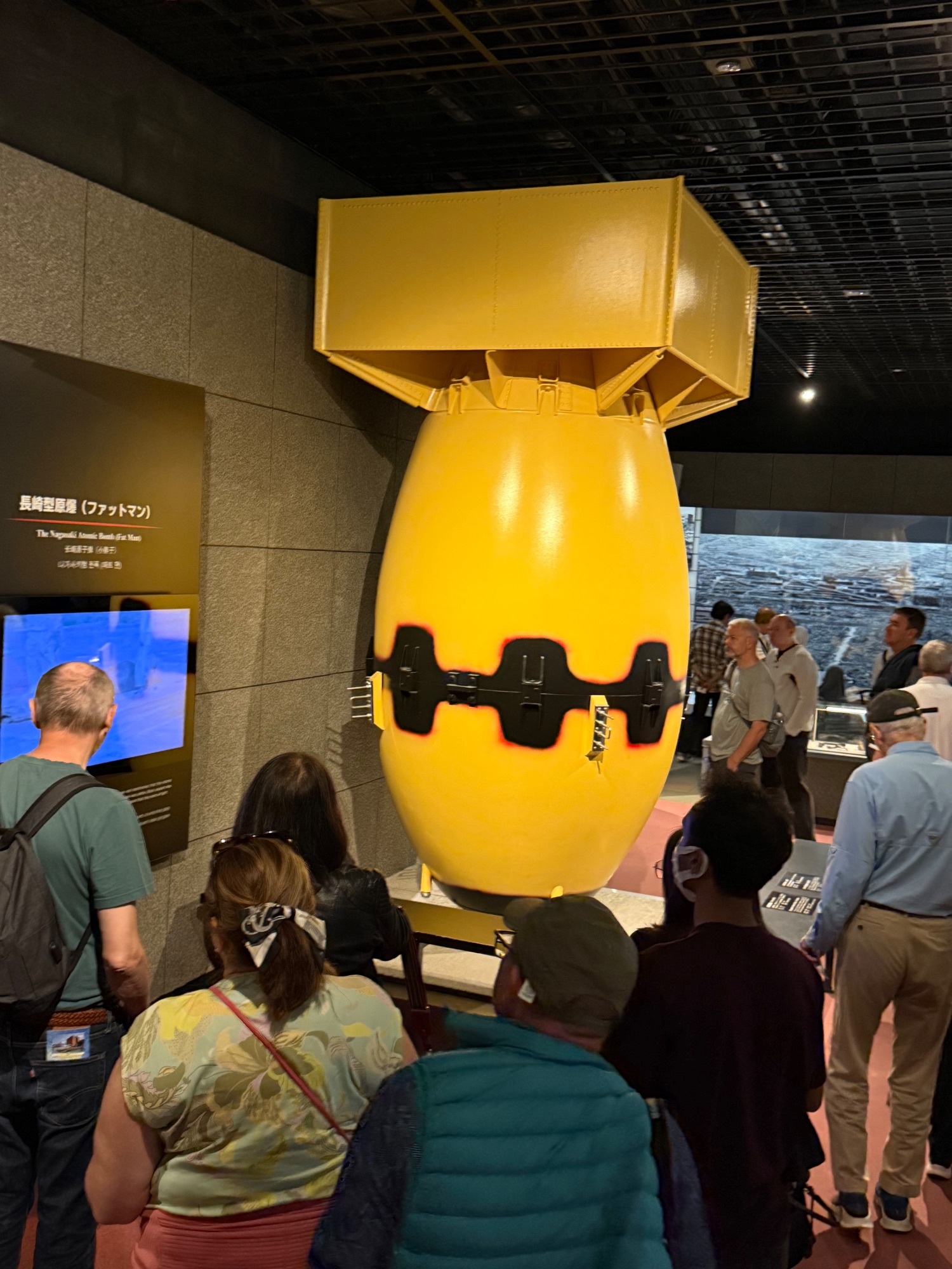Large yellow submarine-like sculpture with black band and face displayed in a museum interior