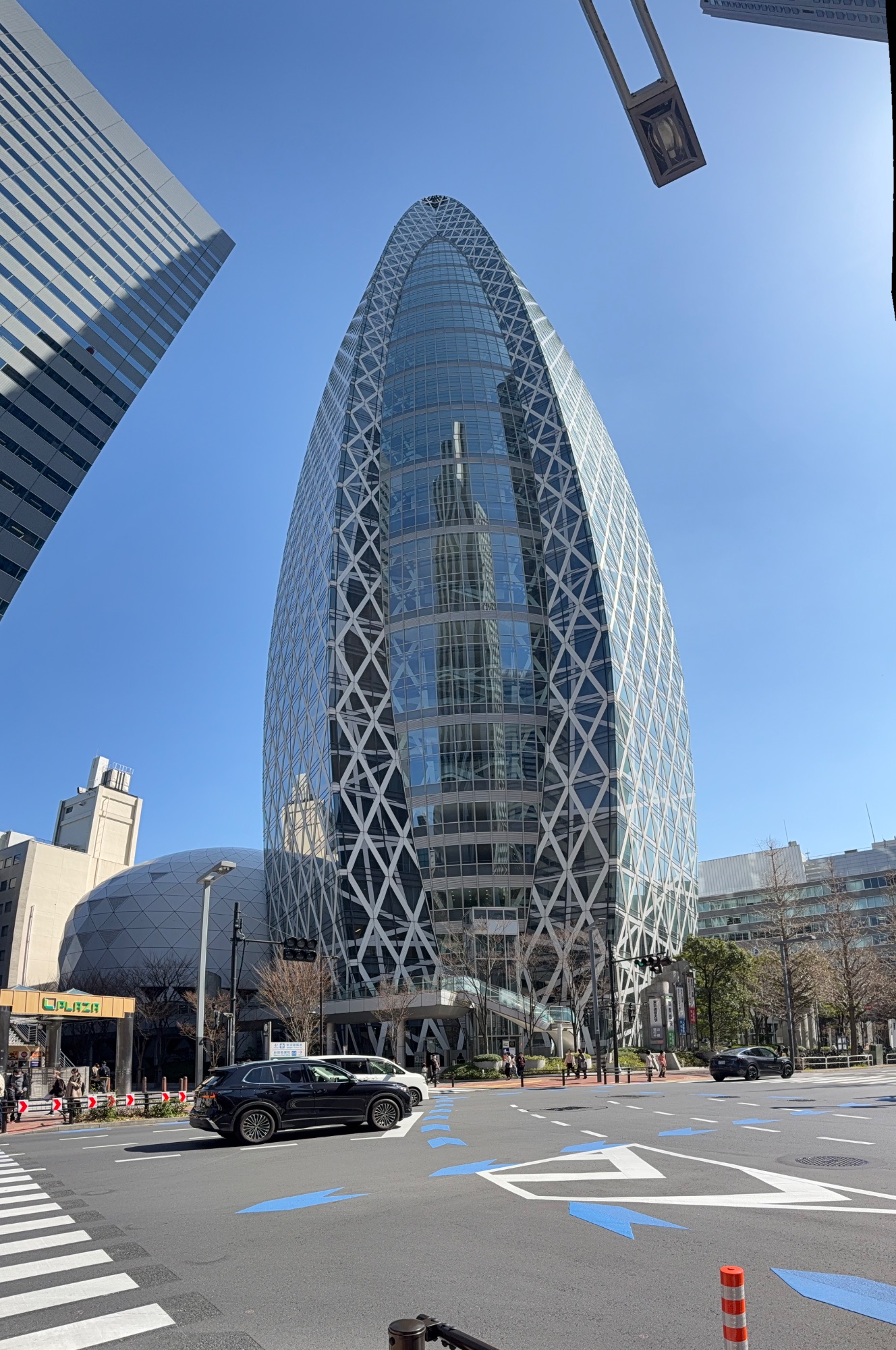 Tall modern cylindrical building with distinctive white lattice pattern against clear sky in Japan