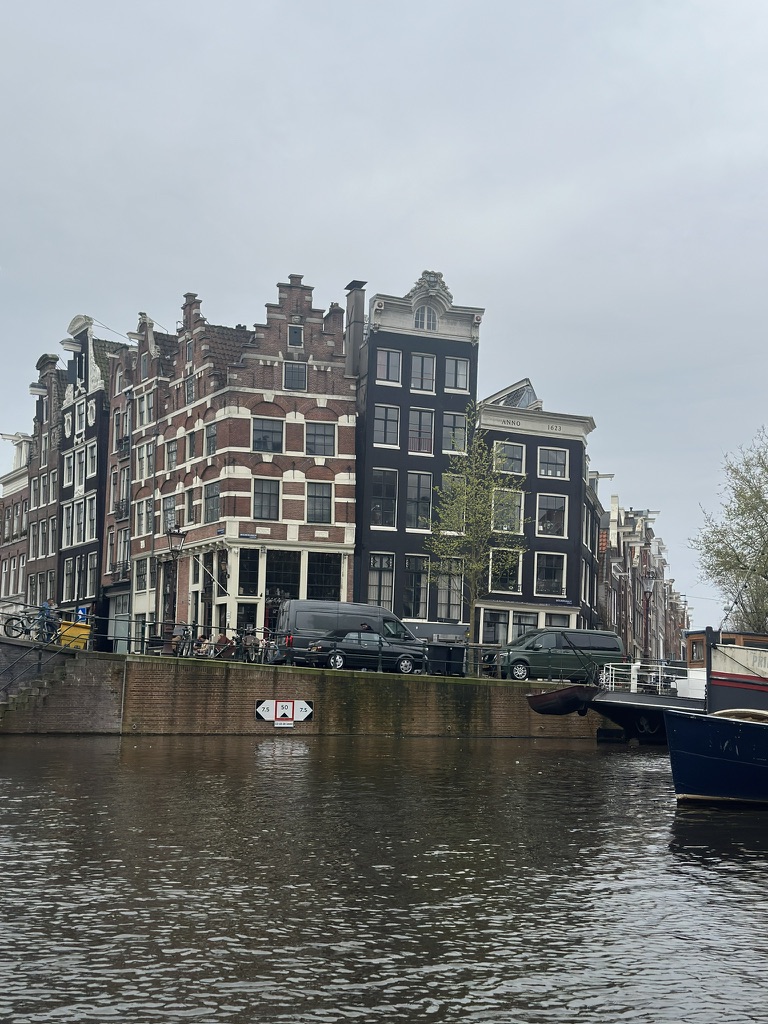 Traditional Dutch canal houses with red brick and ornate gables reflected in still water