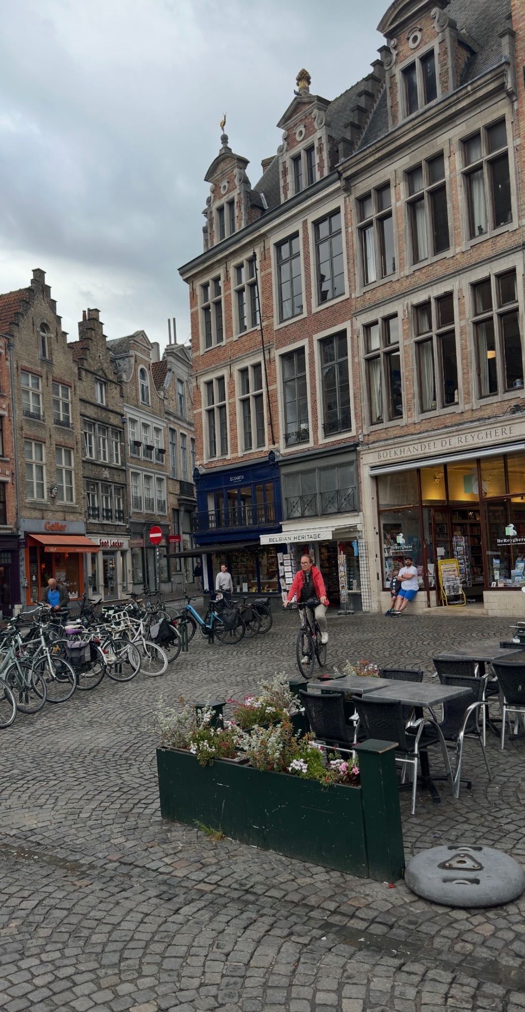 Historic European street lined with traditional brick buildings, bicycles parked along the sidewalk, and shops at street level