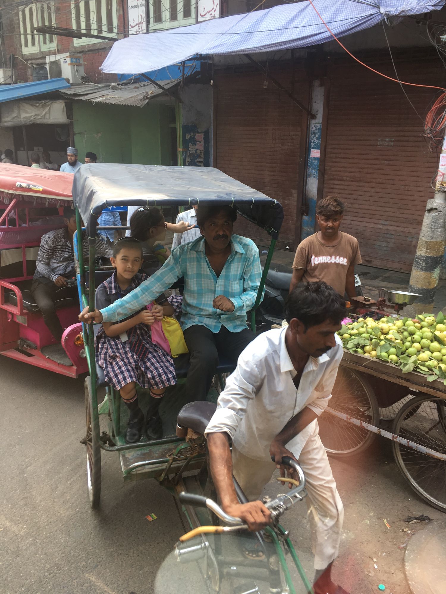Michelle Whalen and a friend ride together in a colorful blue and red auto-rickshaw on an Indian street