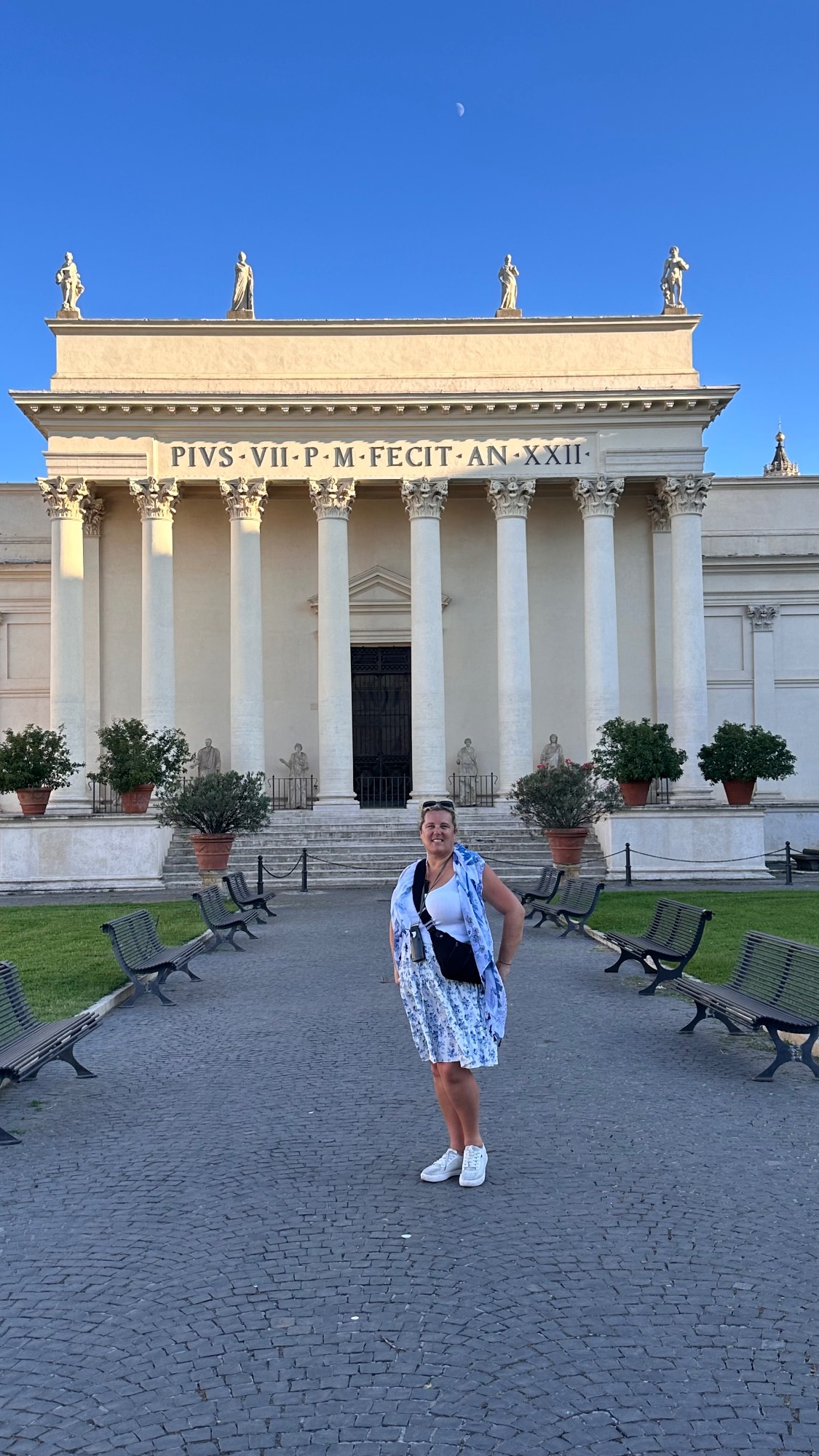 Amanda Beaver stands in front of the Pantheon in Rome, a neoclassical temple with white columns and golden statuary on its roof