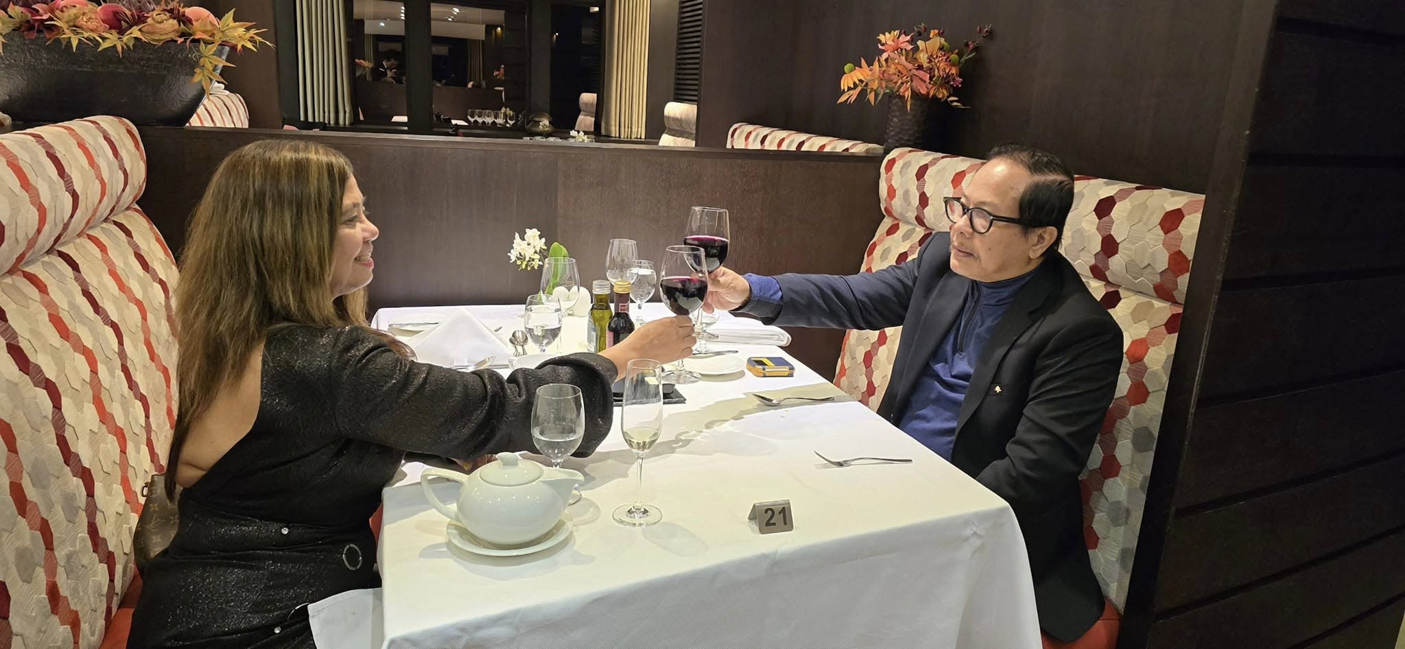 Cleofe Cornelio and dining companion sharing wine at a fine dining restaurant table