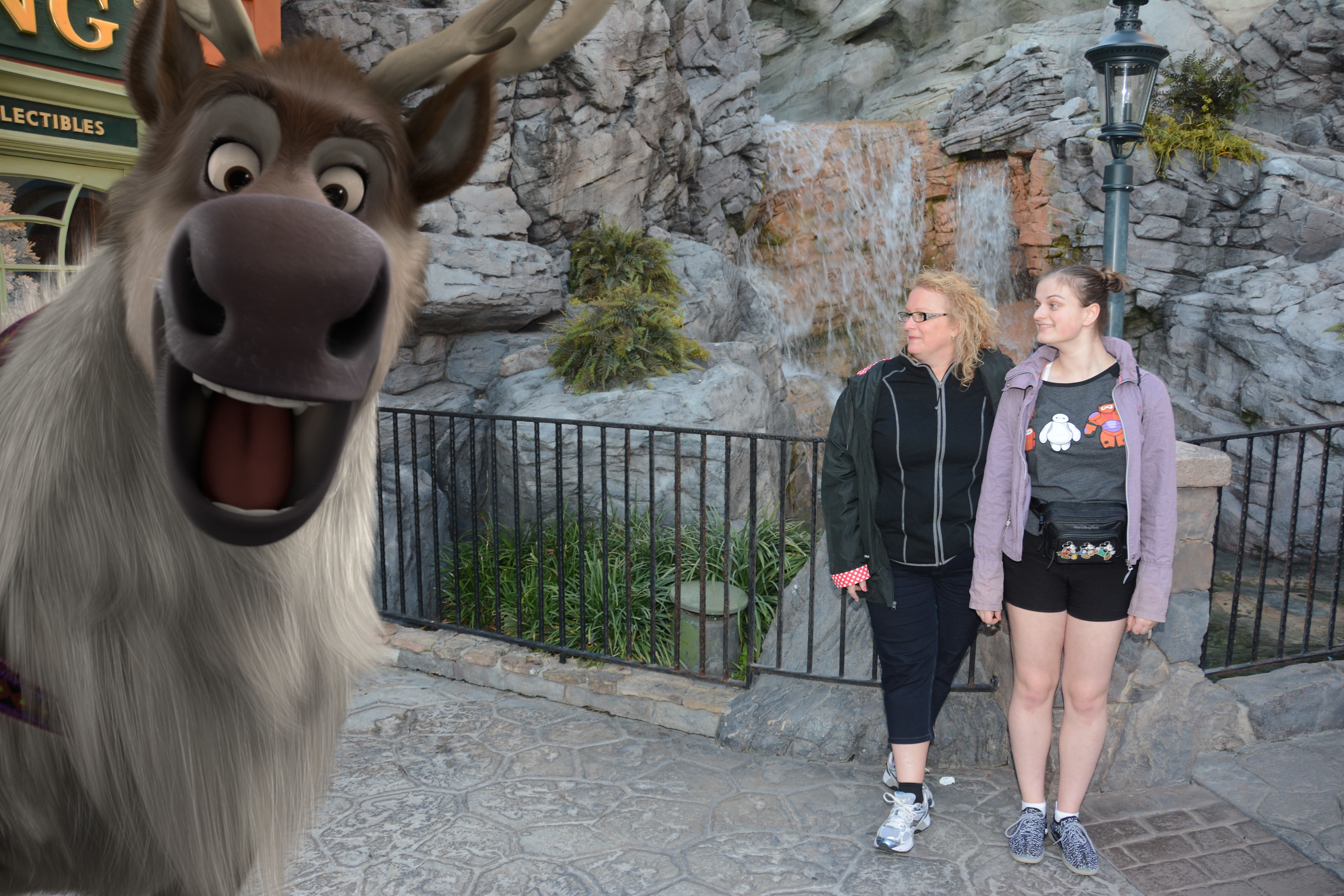 MaryBeth posing with Sven character in front of a rocky mountain backdrop at a Disney park