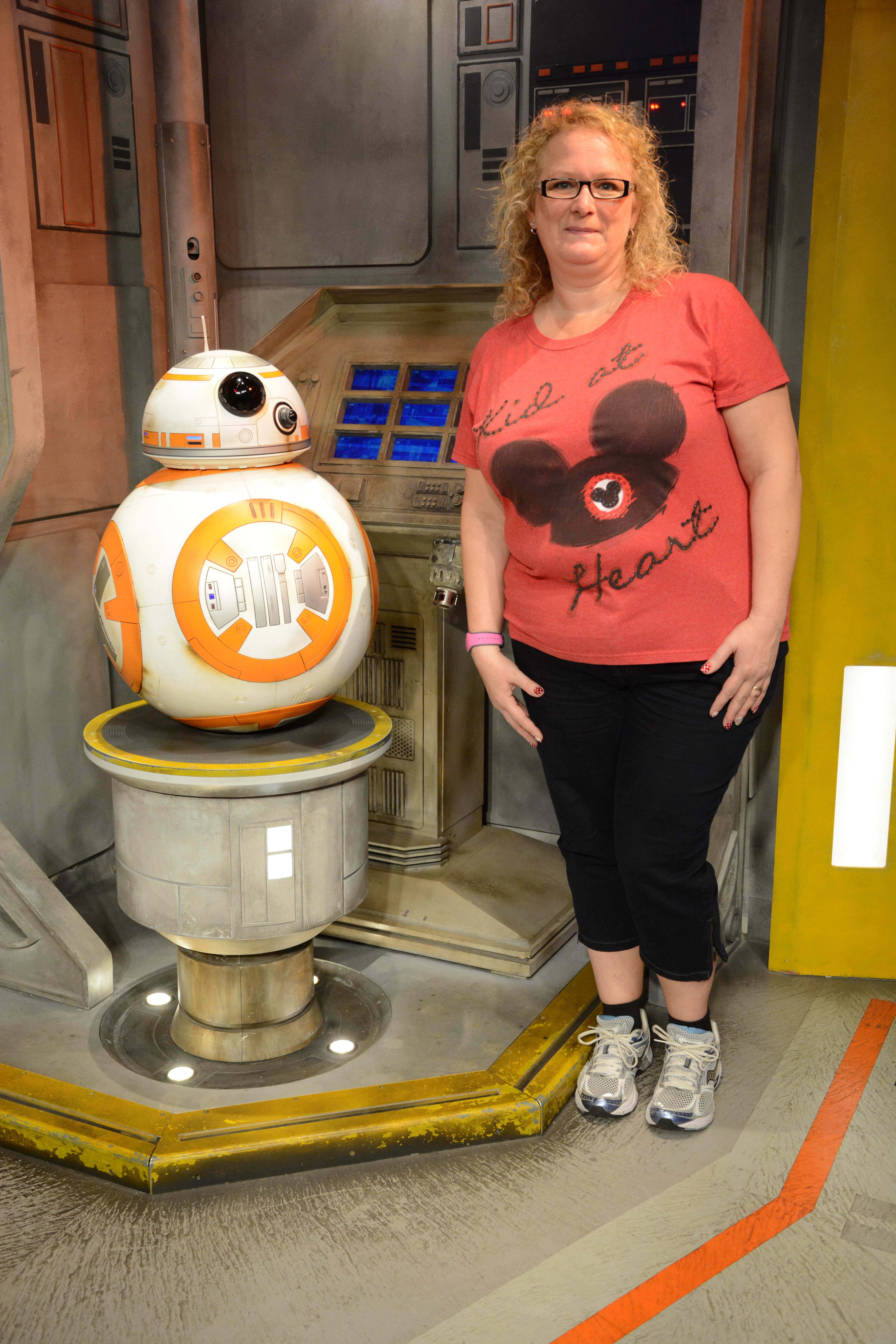 MaryBeth standing next to BB-8 droid figure in a Star Wars-themed indoor attraction setting