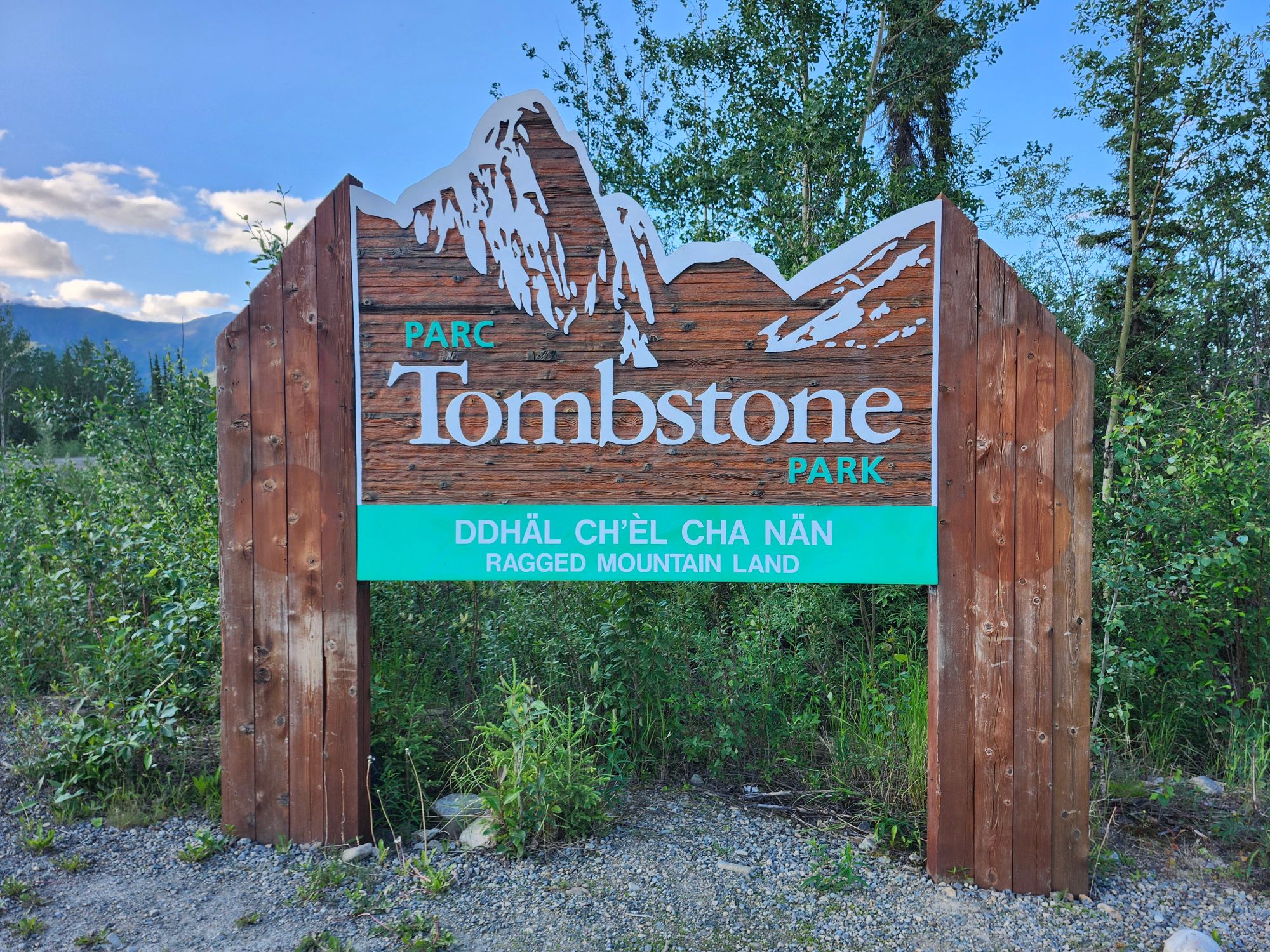 Tombstone Park sign with mountain silhouette against boreal forest and mountains