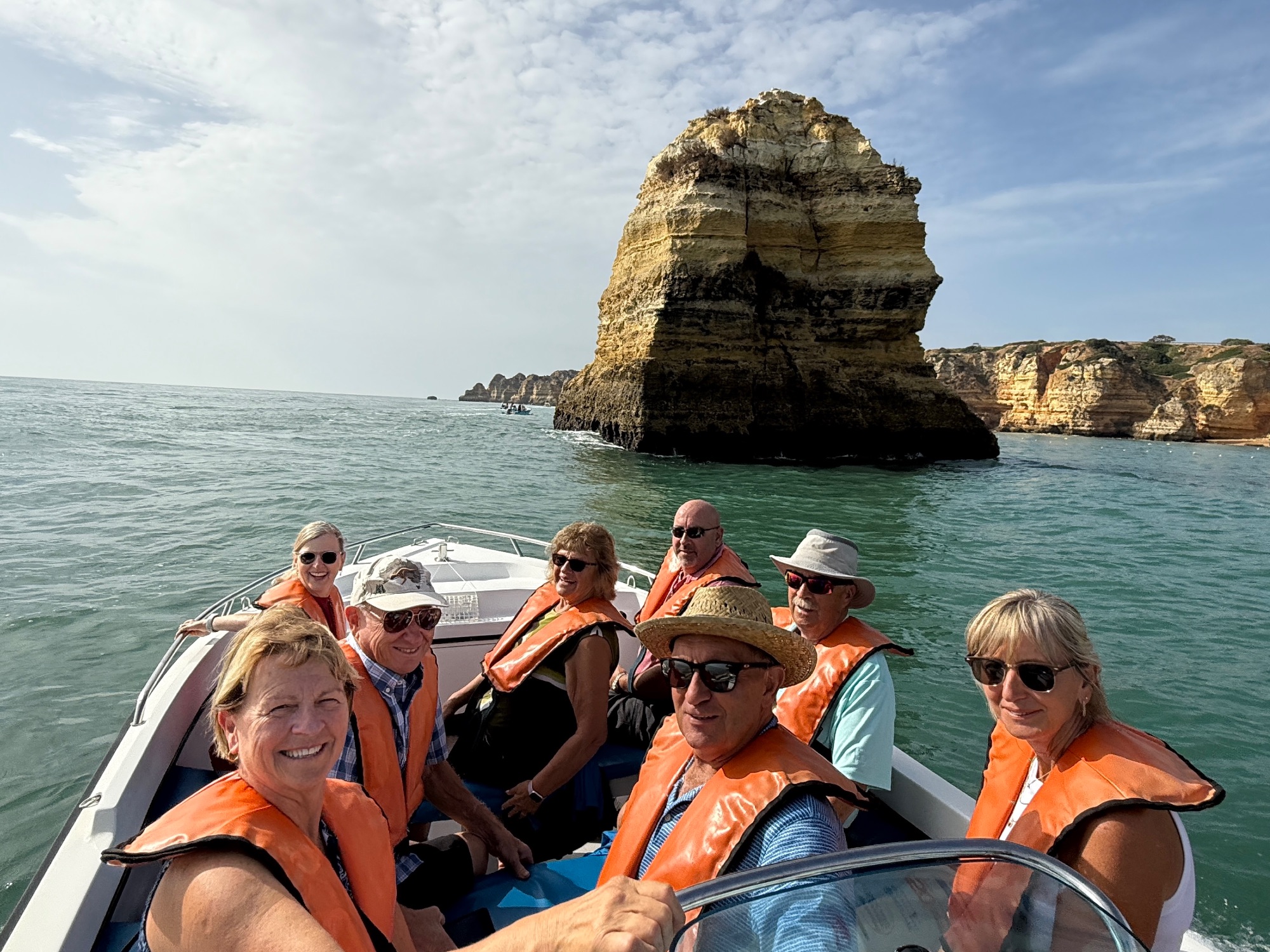 Colorful rock formations and turquoise water visible from inside a sea cave with natural opening