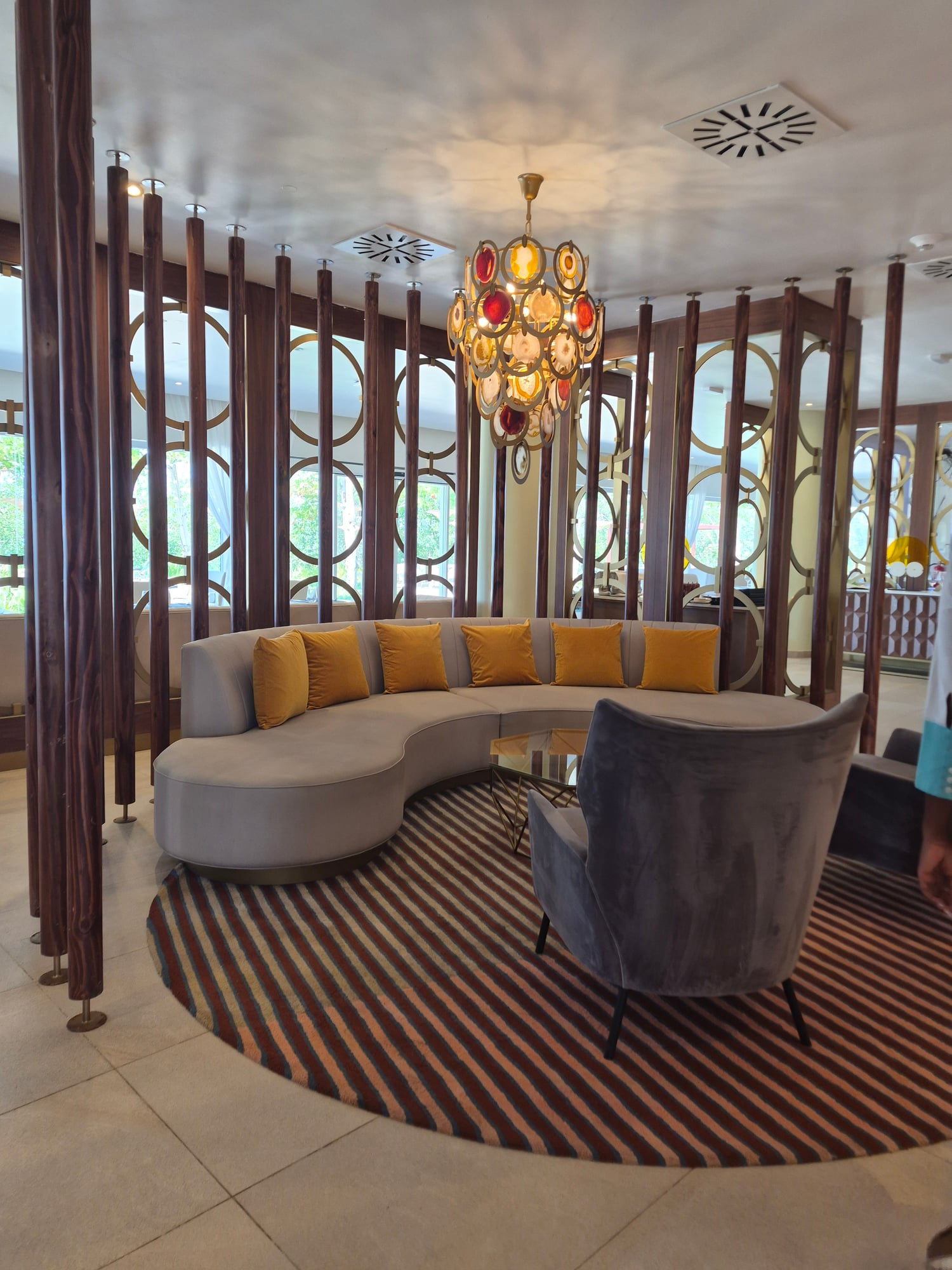 Dining room with red paper lantern ceiling installation and wooden chairs along long tables
