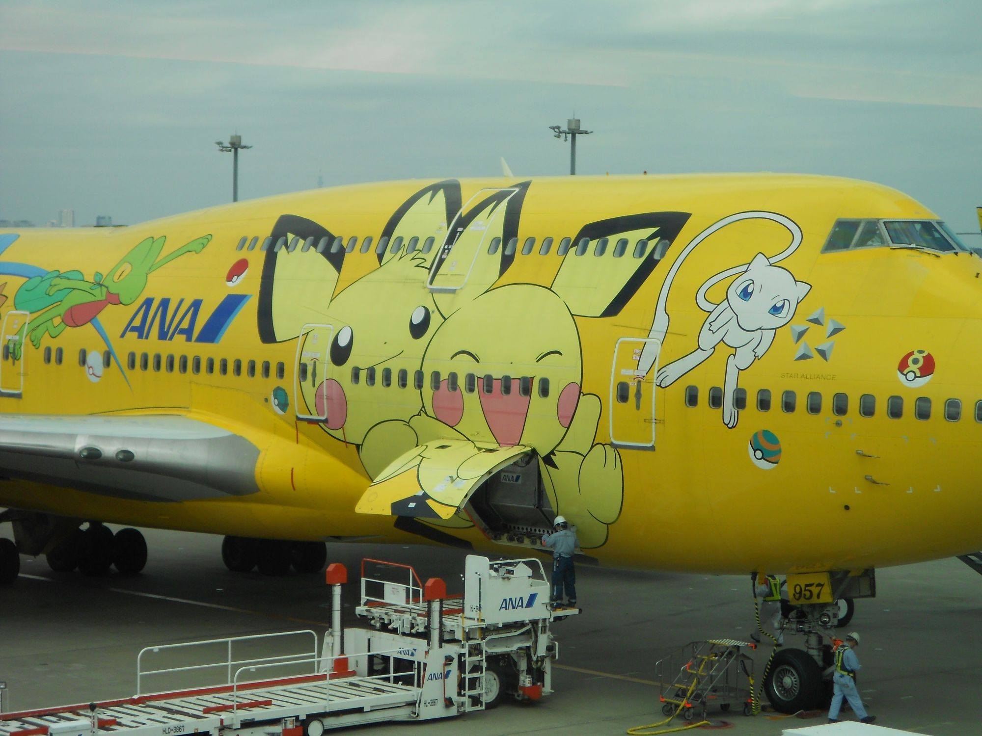 Bright yellow ANA commercial aircraft decorated with Pikachu and other Pokémon characters