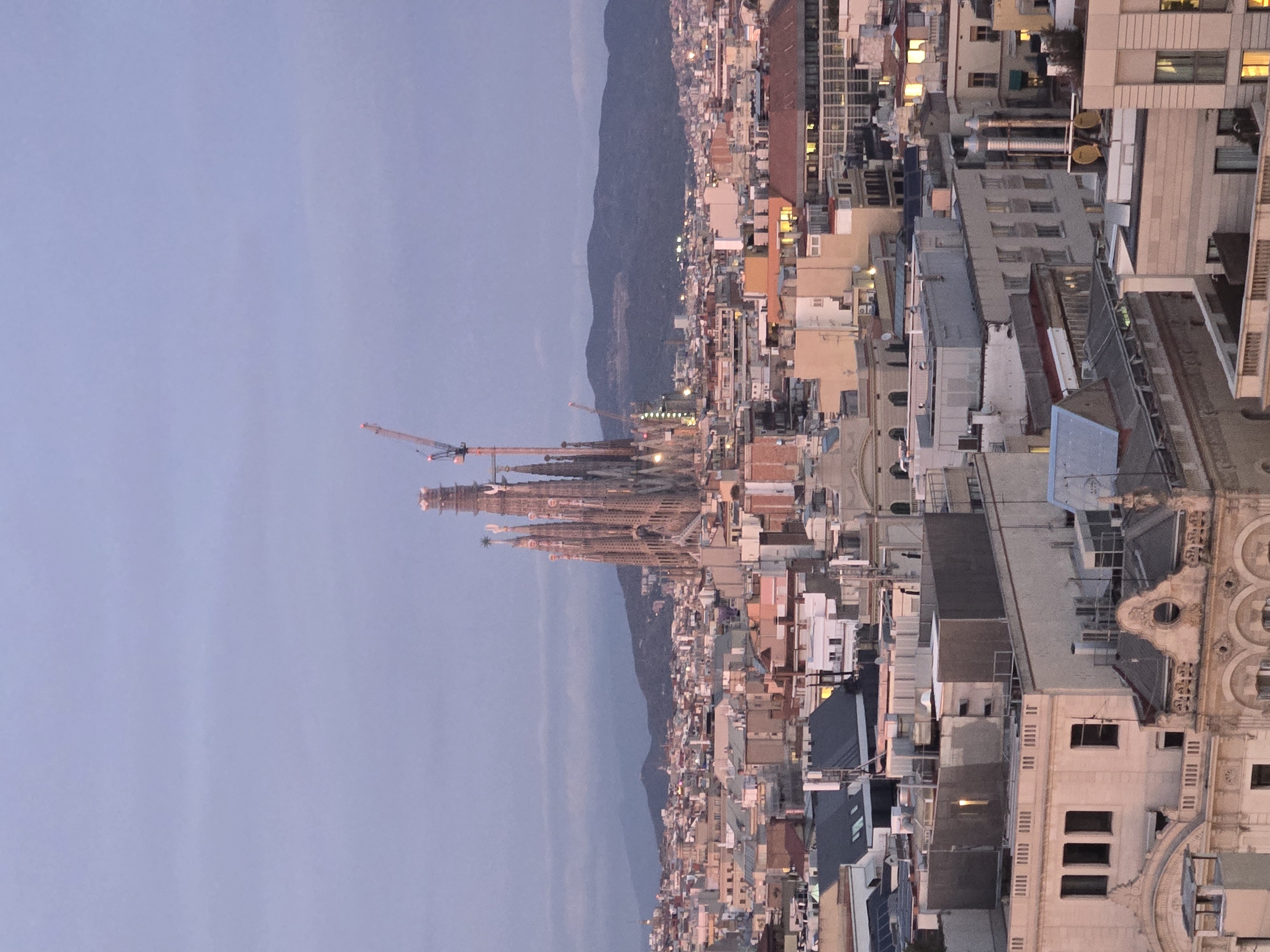 Sagrada Familia basilica at twilight with pink and purple sky over Barcelona cityscape