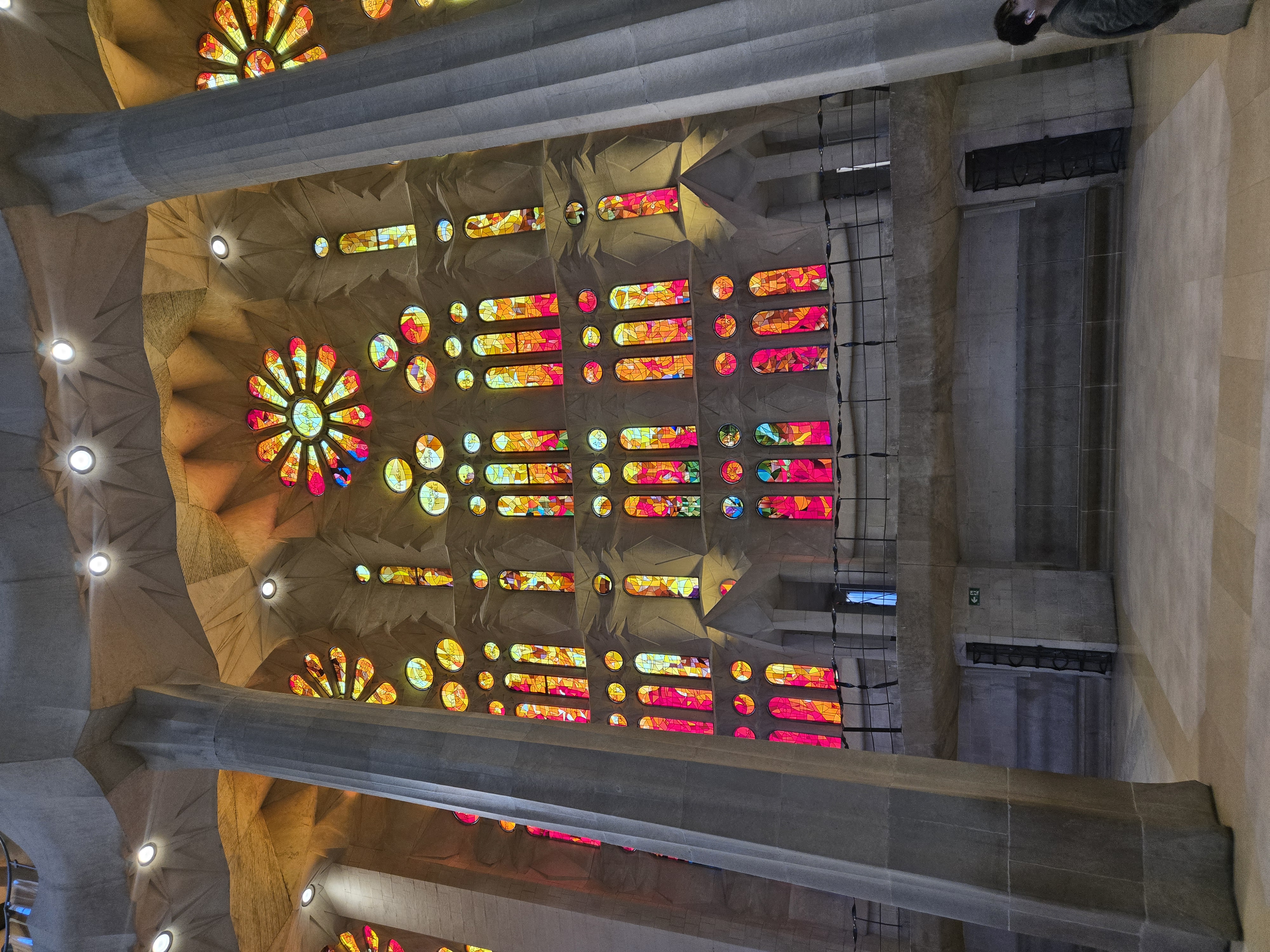 Sagrada Familia's ornate stone facade under construction with cranes against blue sky