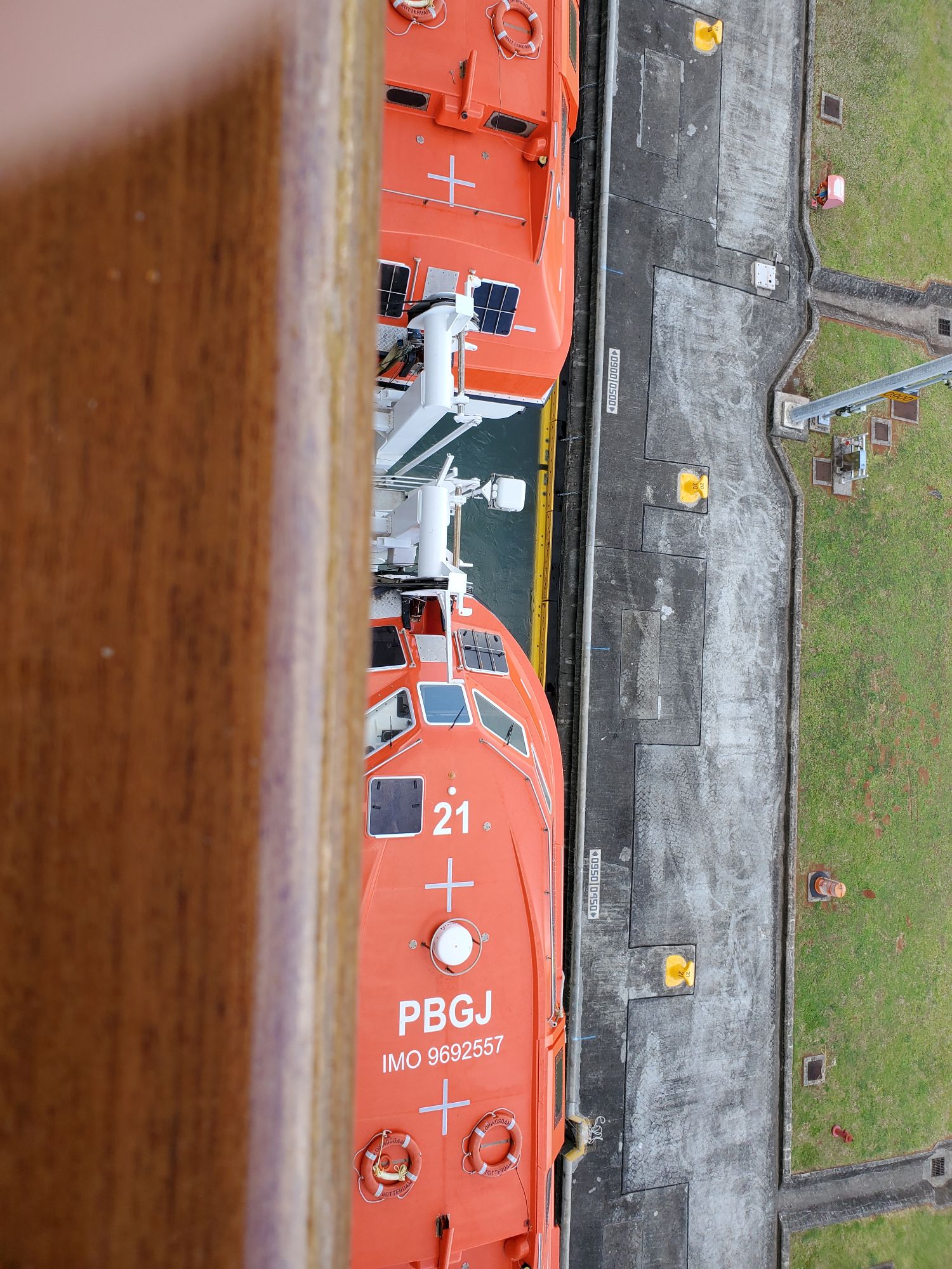 Orange and white rescue vessel numbered 21 moored alongside a concrete dock in Alaska