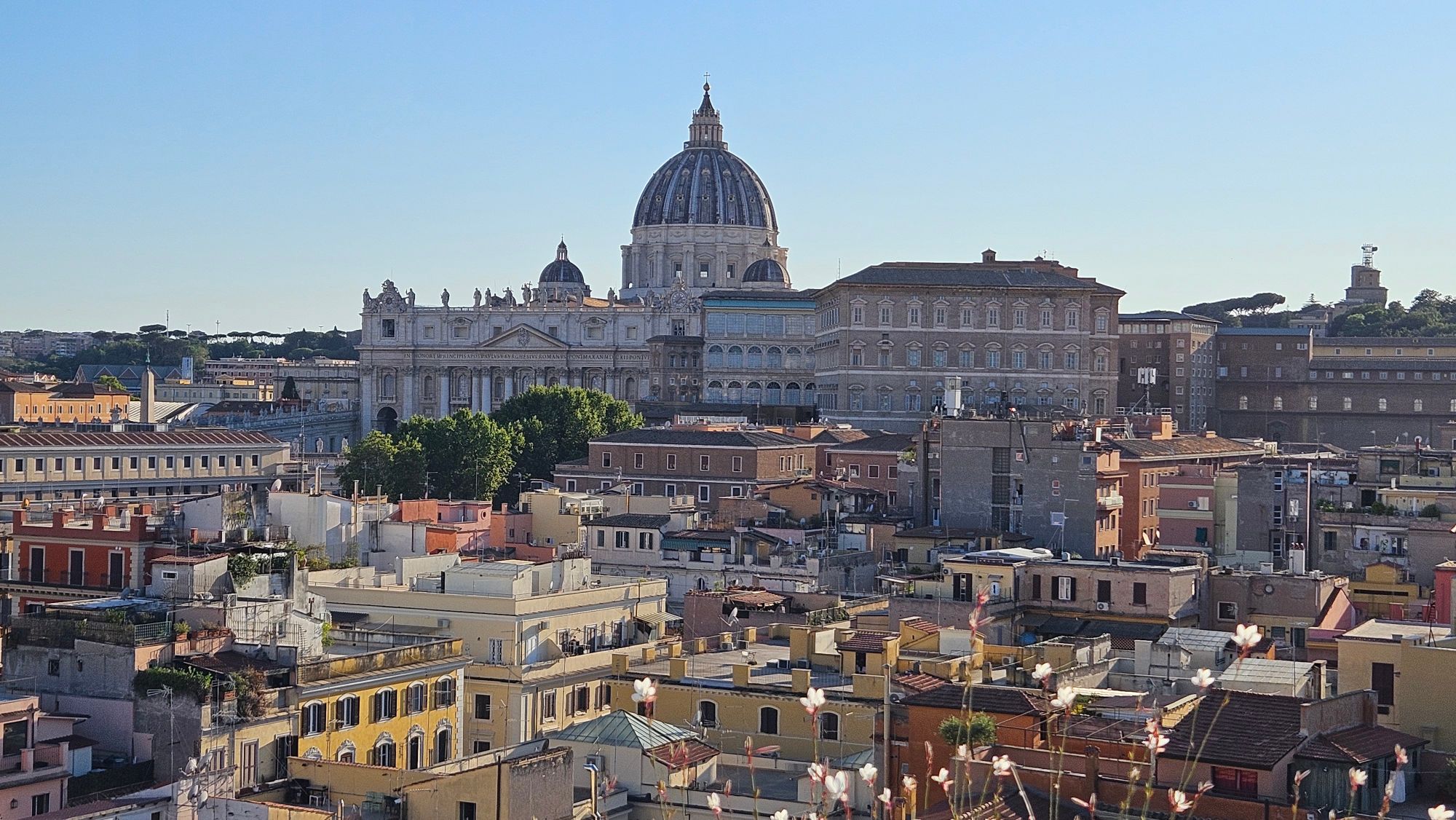 St. Peter's Basilica dome rising above Rome's terracotta rooftops and surrounding buildings