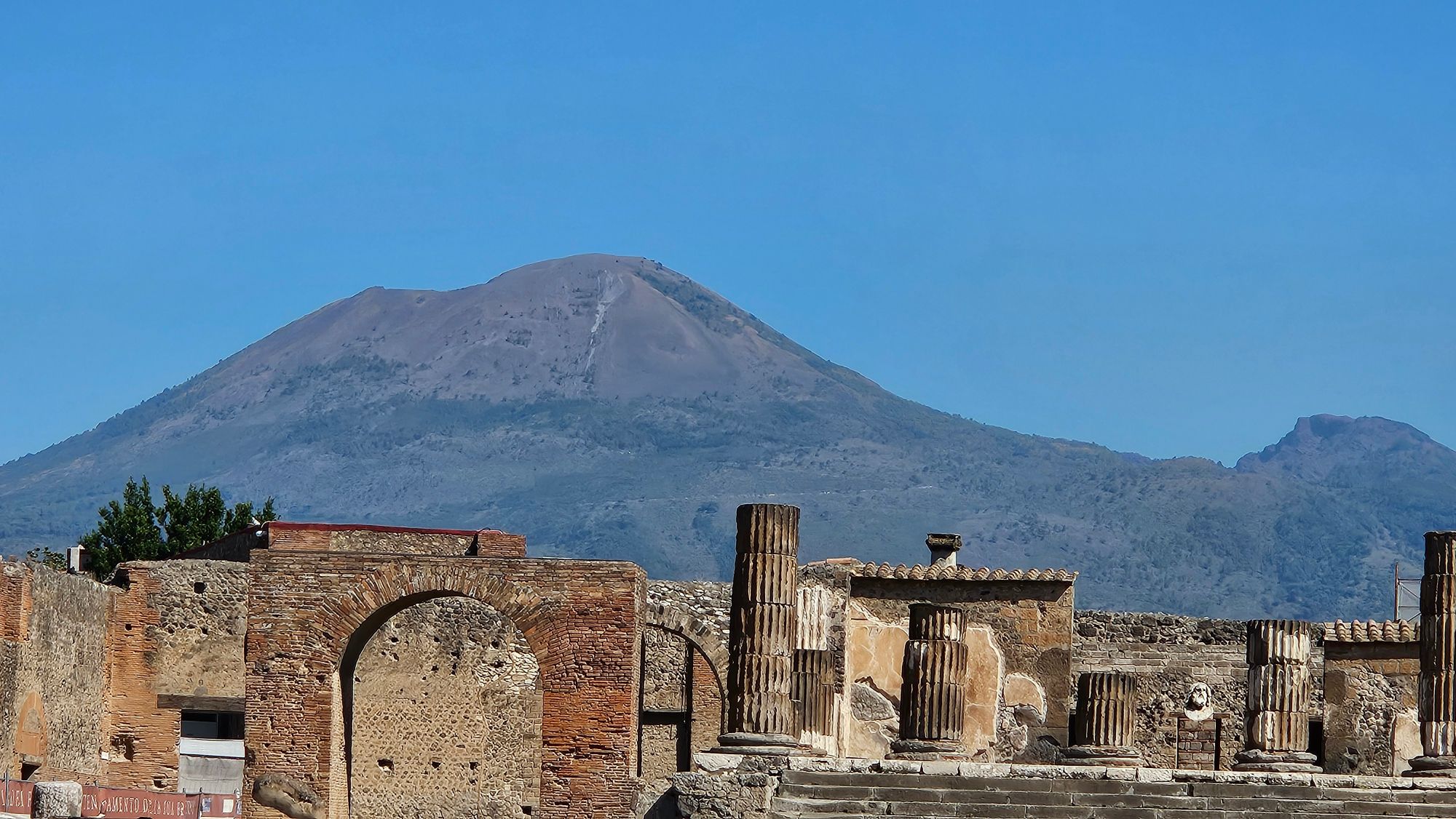 Mount Vesuvius looming behind the coastal city of Naples across the blue Mediterranean Sea