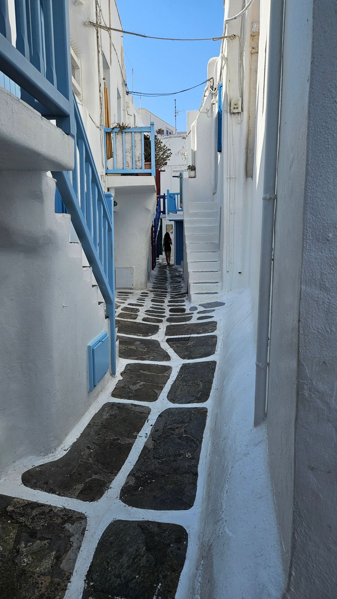 Blue-domed churches with white buildings overlooking the caldera and sea in Santorini at sunset