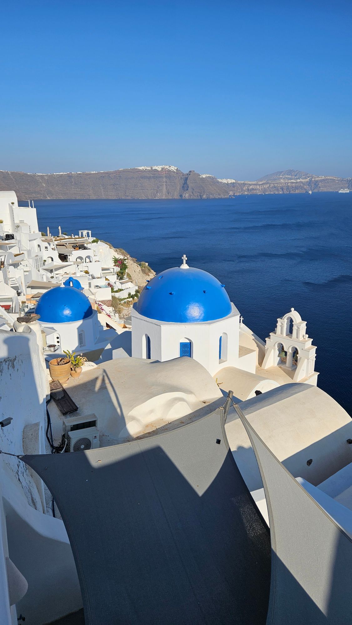 Sunset view over Santorini's caldera with white-washed buildings and cruise ship in the bay