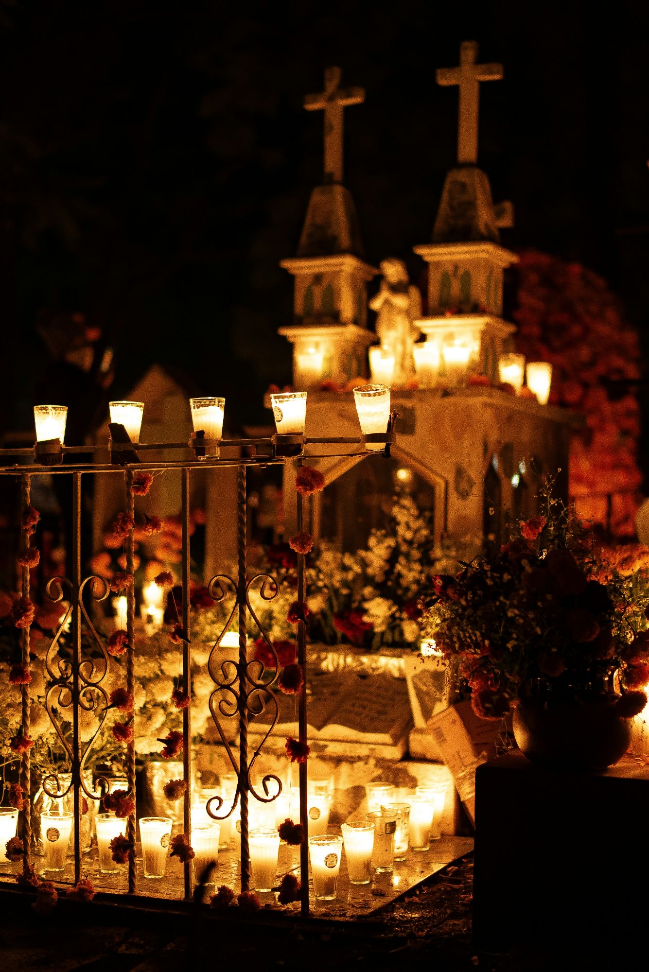 Large skeleton figures with glowing eyes at nighttime Día de Muertos celebration display