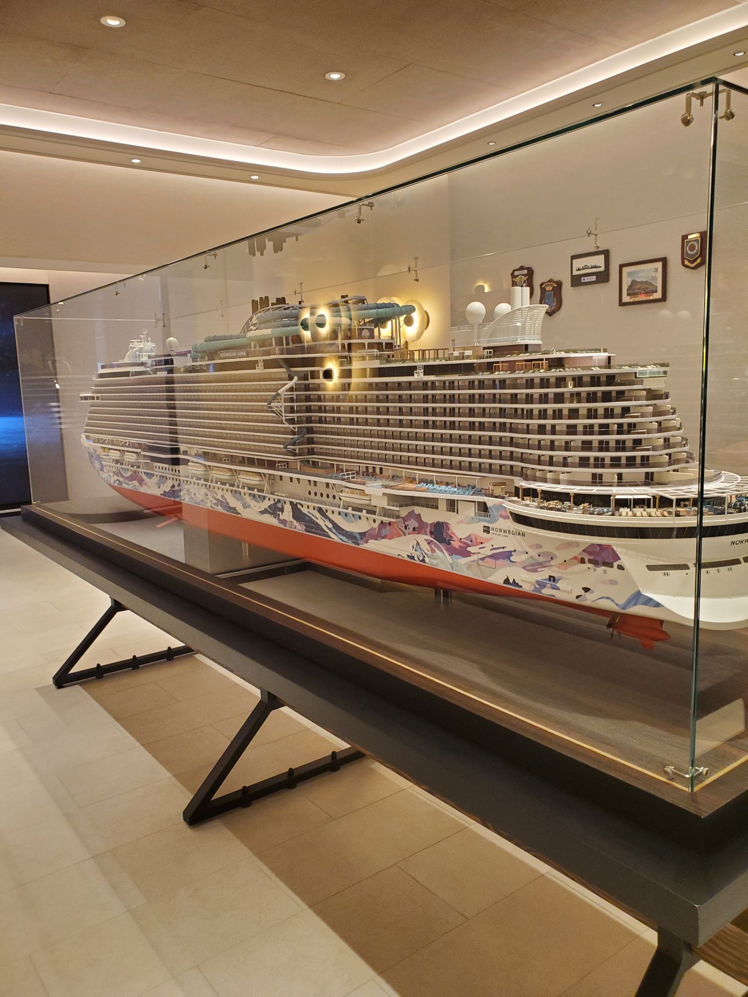 Detailed scale model of Norwegian Luna cruise ship in glass display case with lighting