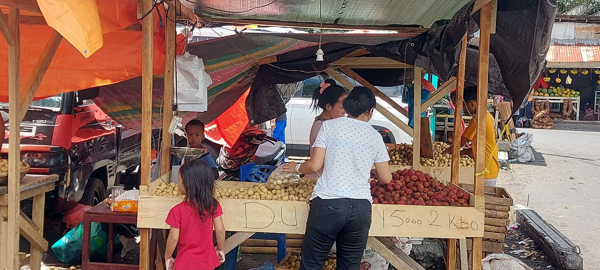 Men processing large fresh tuna fish at waterfront dock in Bitung fishing port