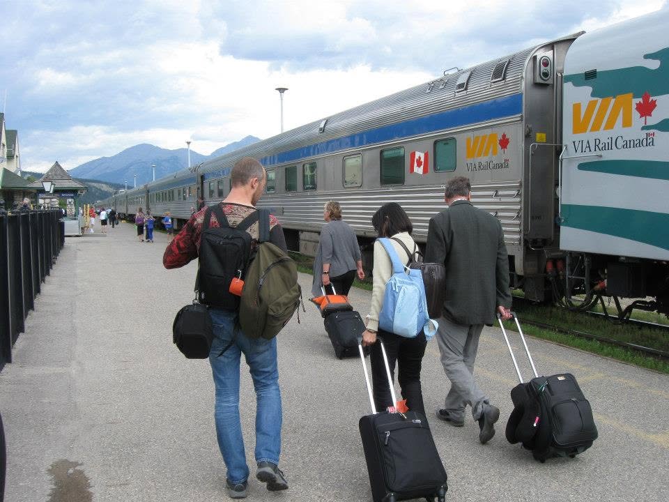 VIA Rail Canada train at platform with passengers boarding with luggage