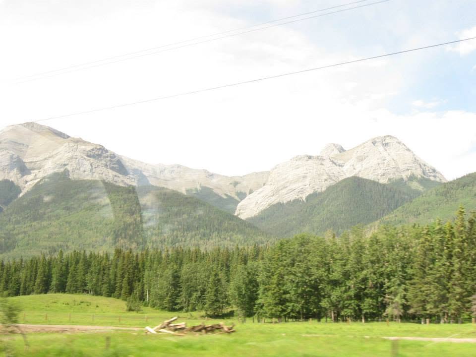 Mountain landscape visible through curved glass windows of a dome car on a train