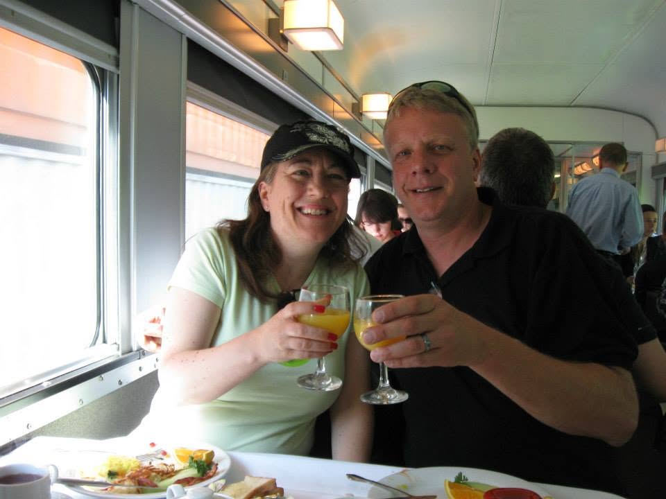 Elegant dining setup with white tablecloth and tea service in a train observation car