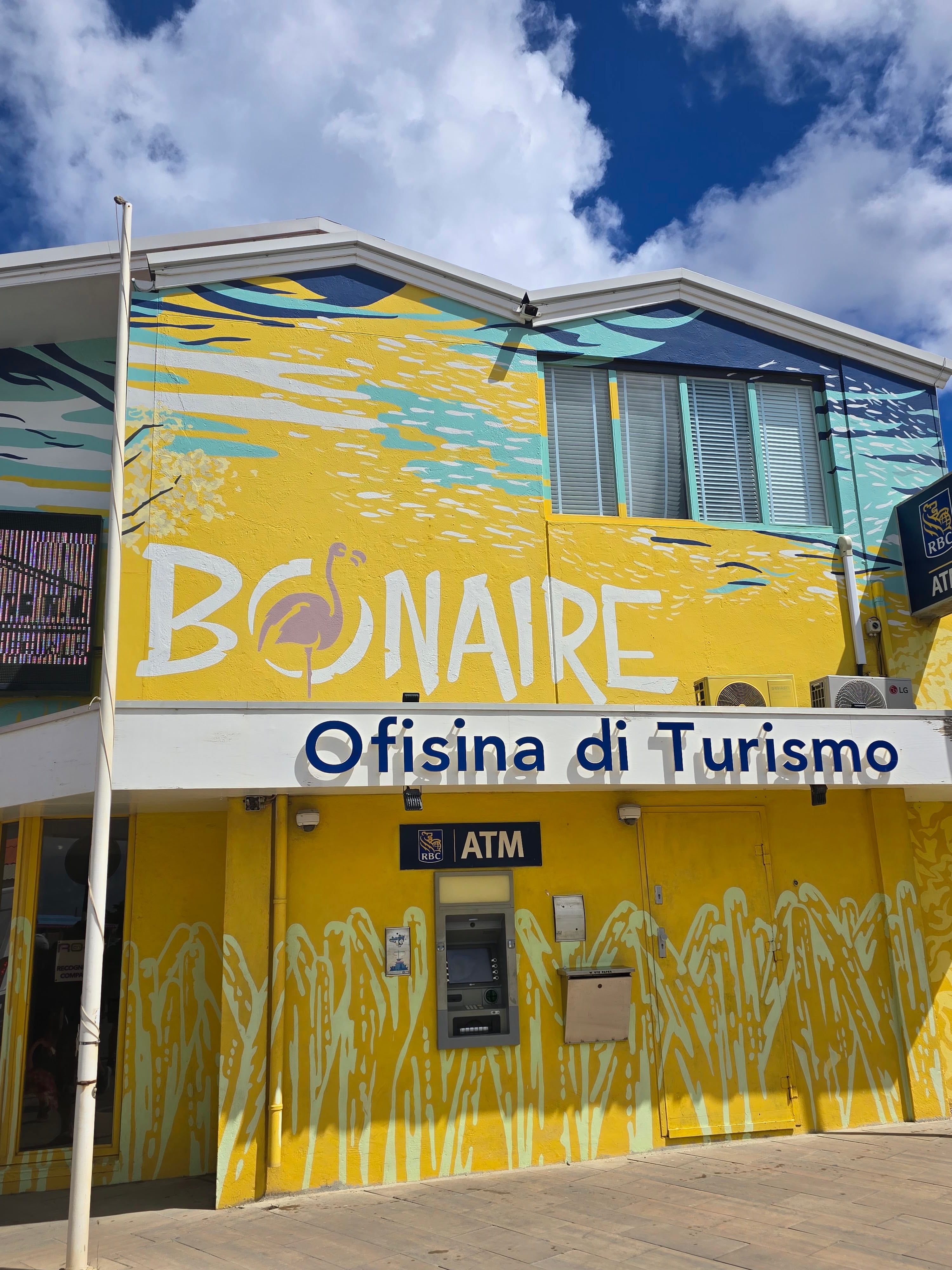 Yellow tourism office building with 'Bonaire' text and stylized fish artwork on facade