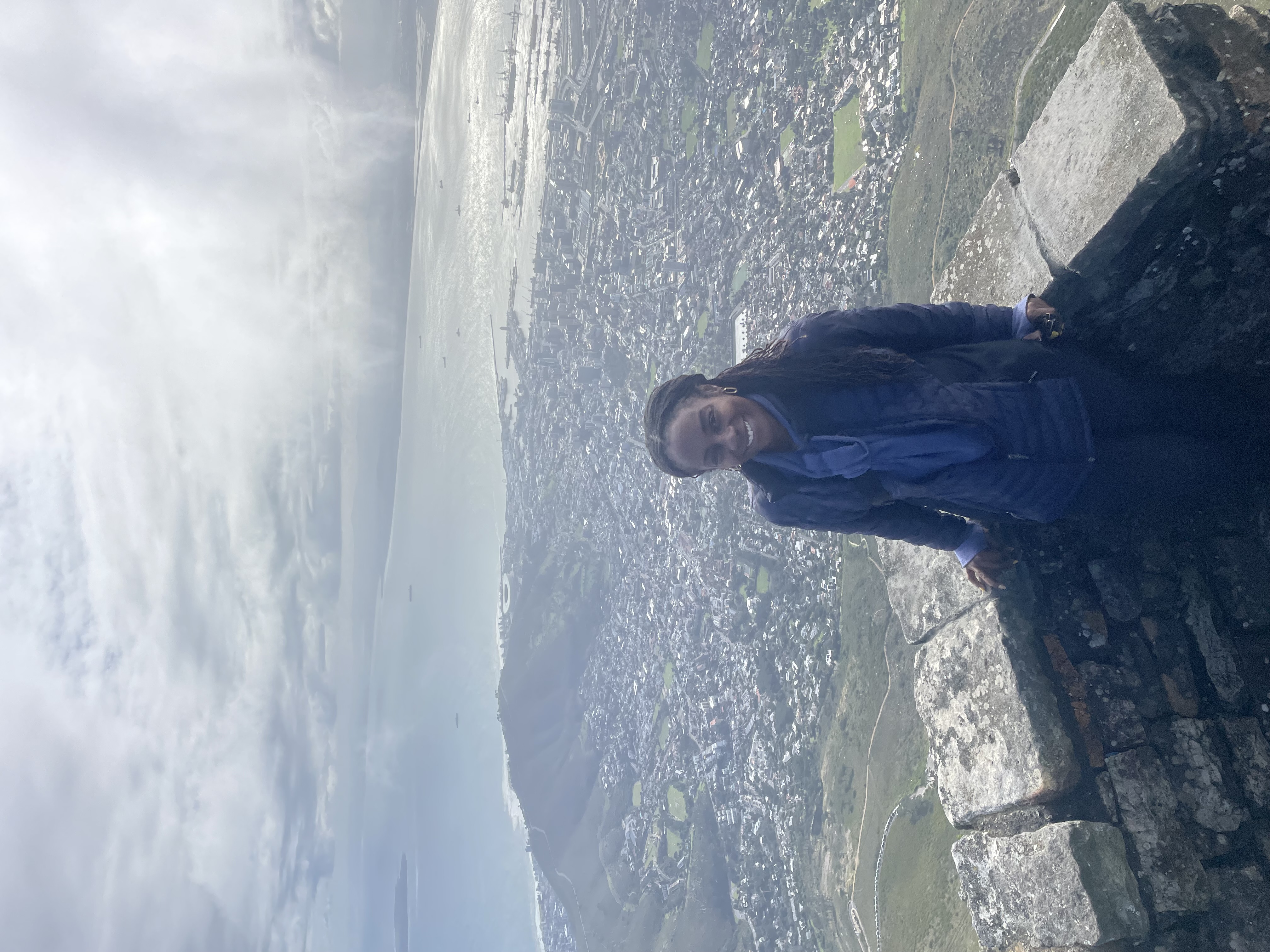 Roz at the top of Table Mountain with aerial view of Cape Town and the bay below